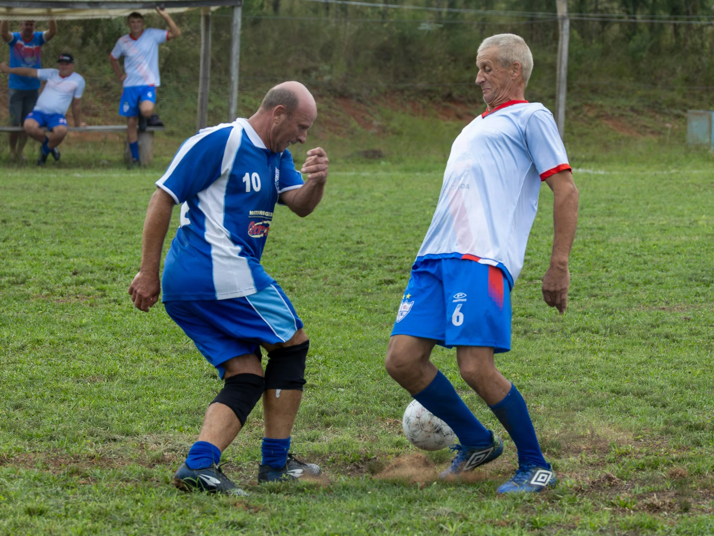 Two older soccer players playing against each other on a field, highlighting the need for community recreation and social interaction
for older adults.
