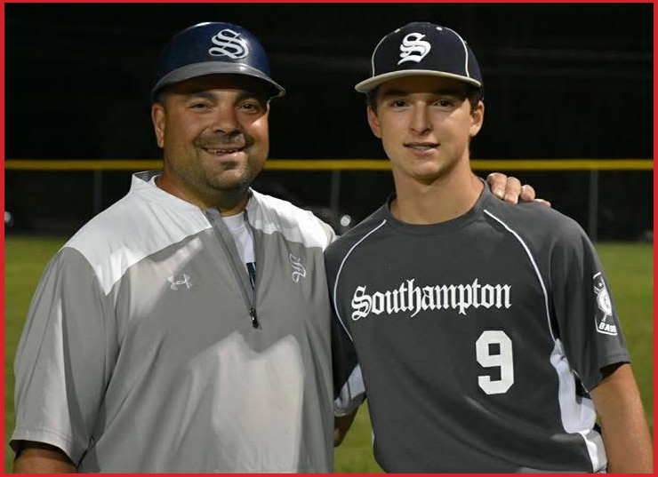 Two baseball players wearing black hats with a white 'S' logo; one in a gray jacket, the other in a black Southampton jersey with the number 9, standing on a baseball field at night.