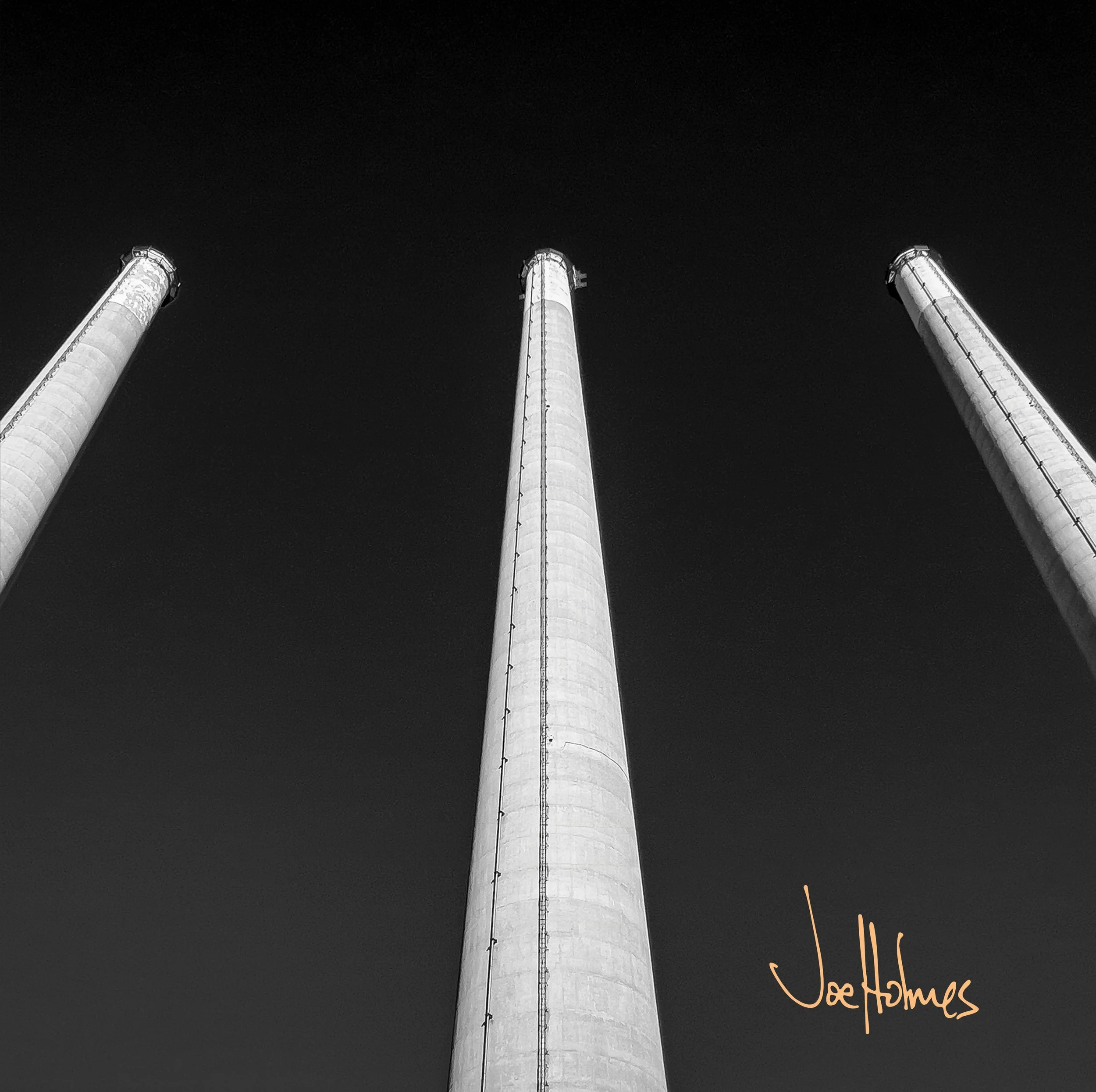 Low-angle view of three tall industrial chimneys against a dark night sky, with some glowing orange sparks at the base and the word 'thank you' written in orange cursive text at the bottom right.