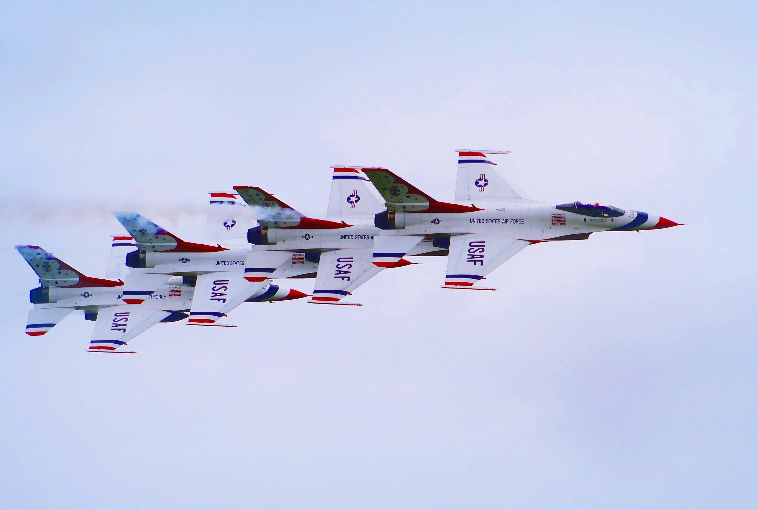 A formation of United States Air Force fighter jets flying in the sky.