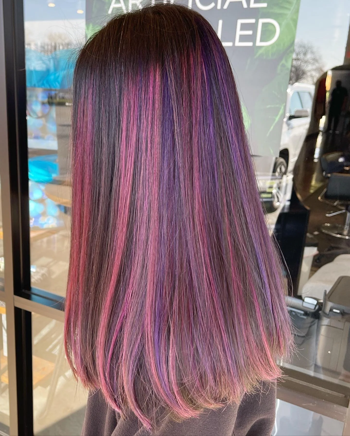 Long straight hair with vibrant pink and purple streaks.