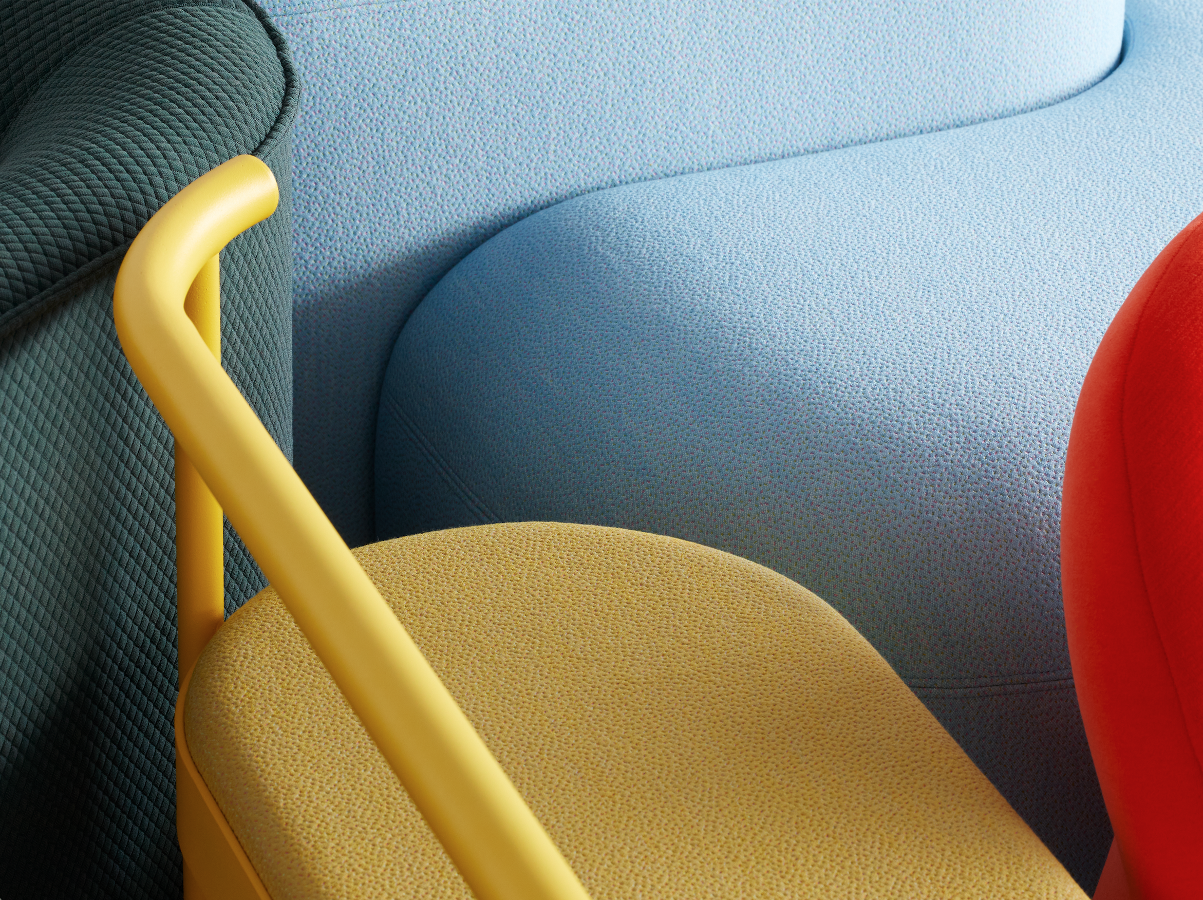 Close-up of colorful, textured upholstered chairs with a yellow armrest in the foreground.