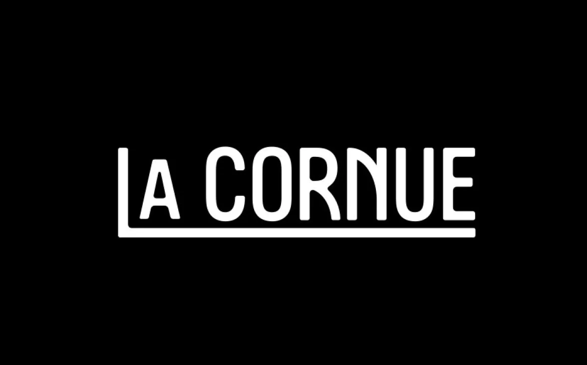 Black background with white text that reads 'LA CORNUE' in a bold font, with a line underneath.