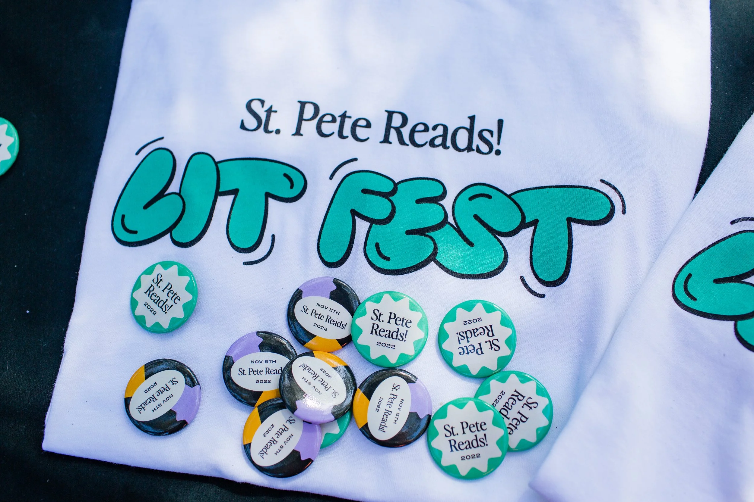 St. Pete Reads! Lit Fest T-shirt and colorful event buttons from the 2022 literacy festival in St. Petersburg, Florida.