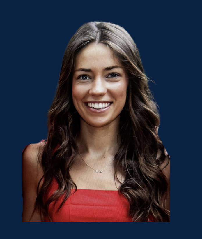 Portrait of a young woman with long wavy brown hair, wearing a red top and a delicate necklace with an infinity symbol, smiling against a dark blue background.