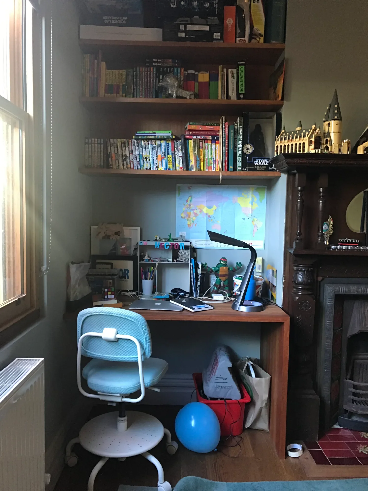 Boys' room at a Pledge Builders project before styling, with a cluttered desk, shelves and a pale blue chair.