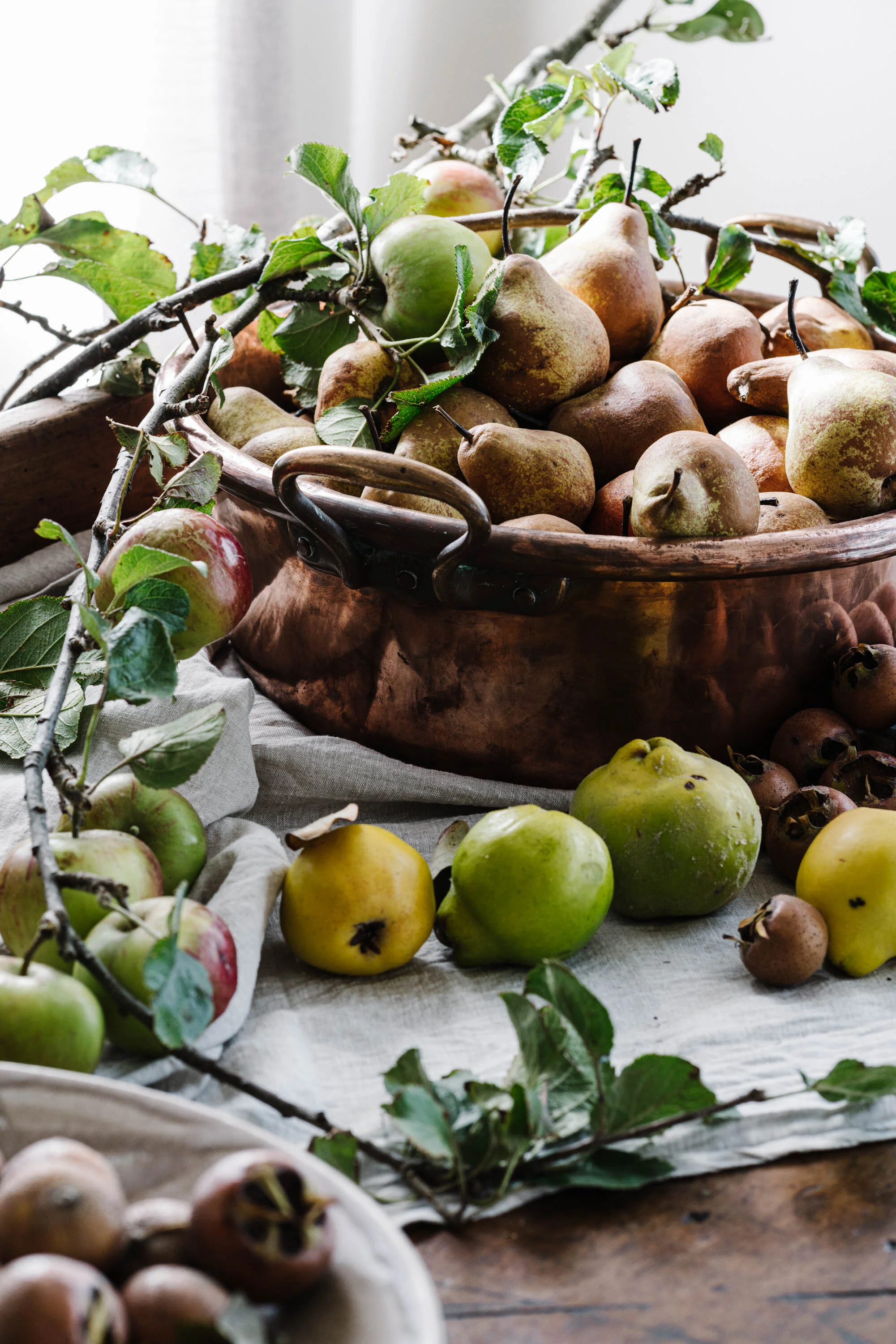 Autumn produce spilling from a basket onto a table, fine art photograph