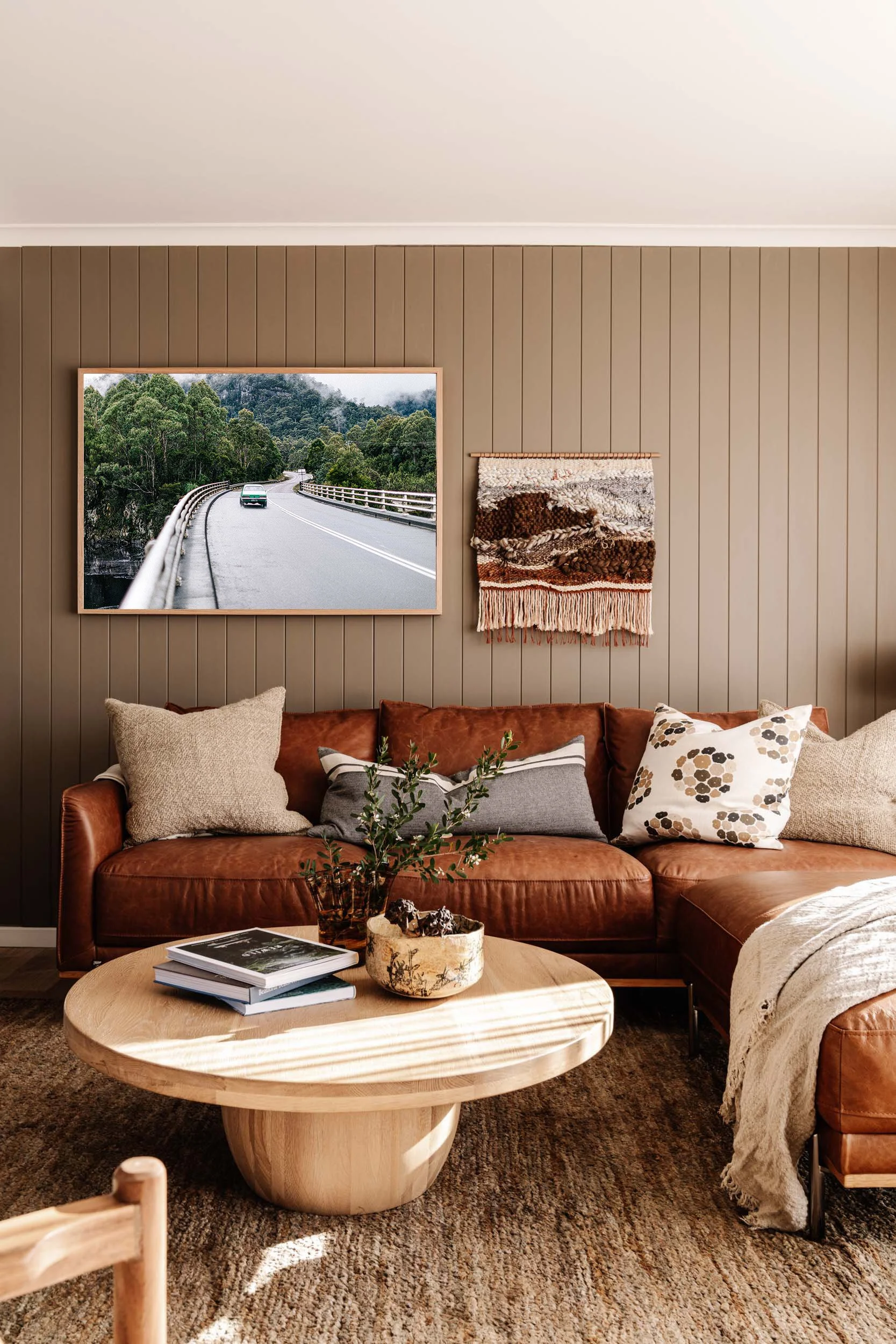 On the Road from Strahan print above a tan leather sofa