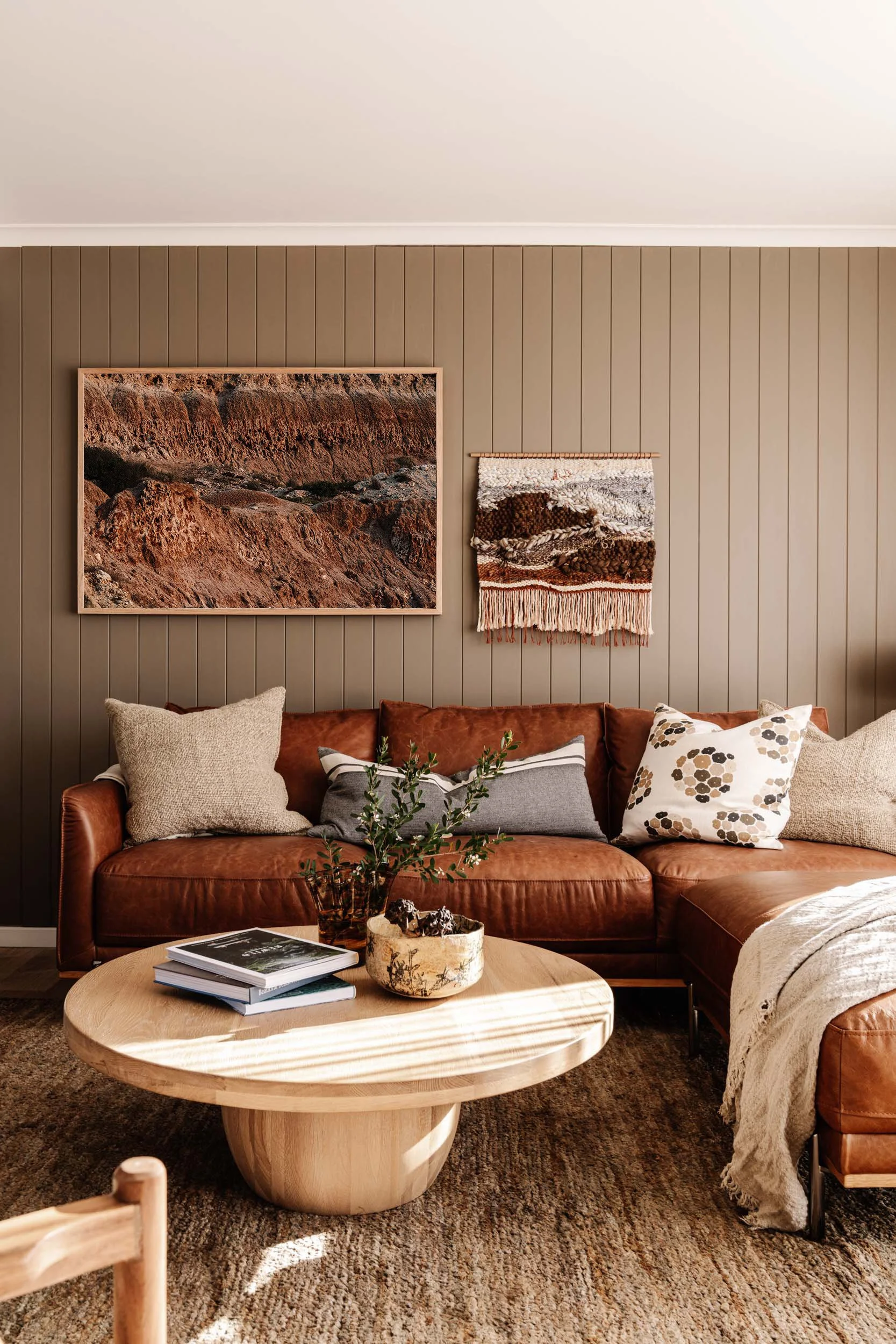 Red Earth print above a tan leather sofa