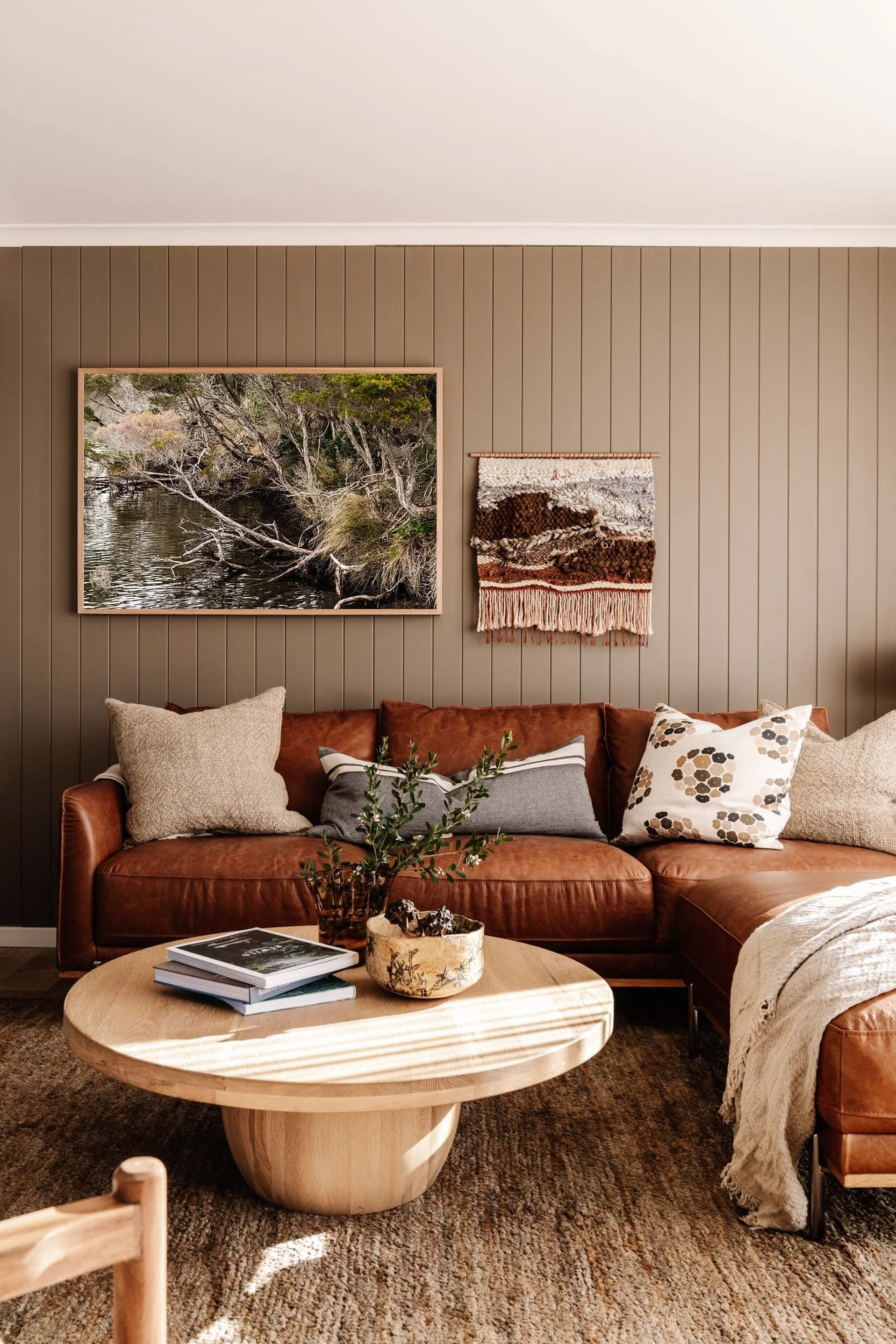 Lake Dove branches print above a tan leather sofa