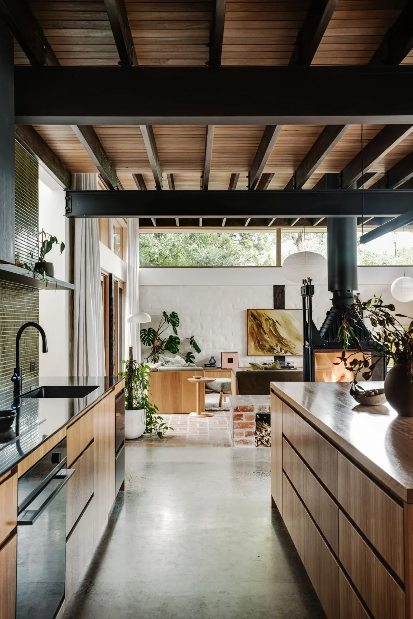 Kitchen at Mudbrick House, Eltham, with a timber island under exposed beams