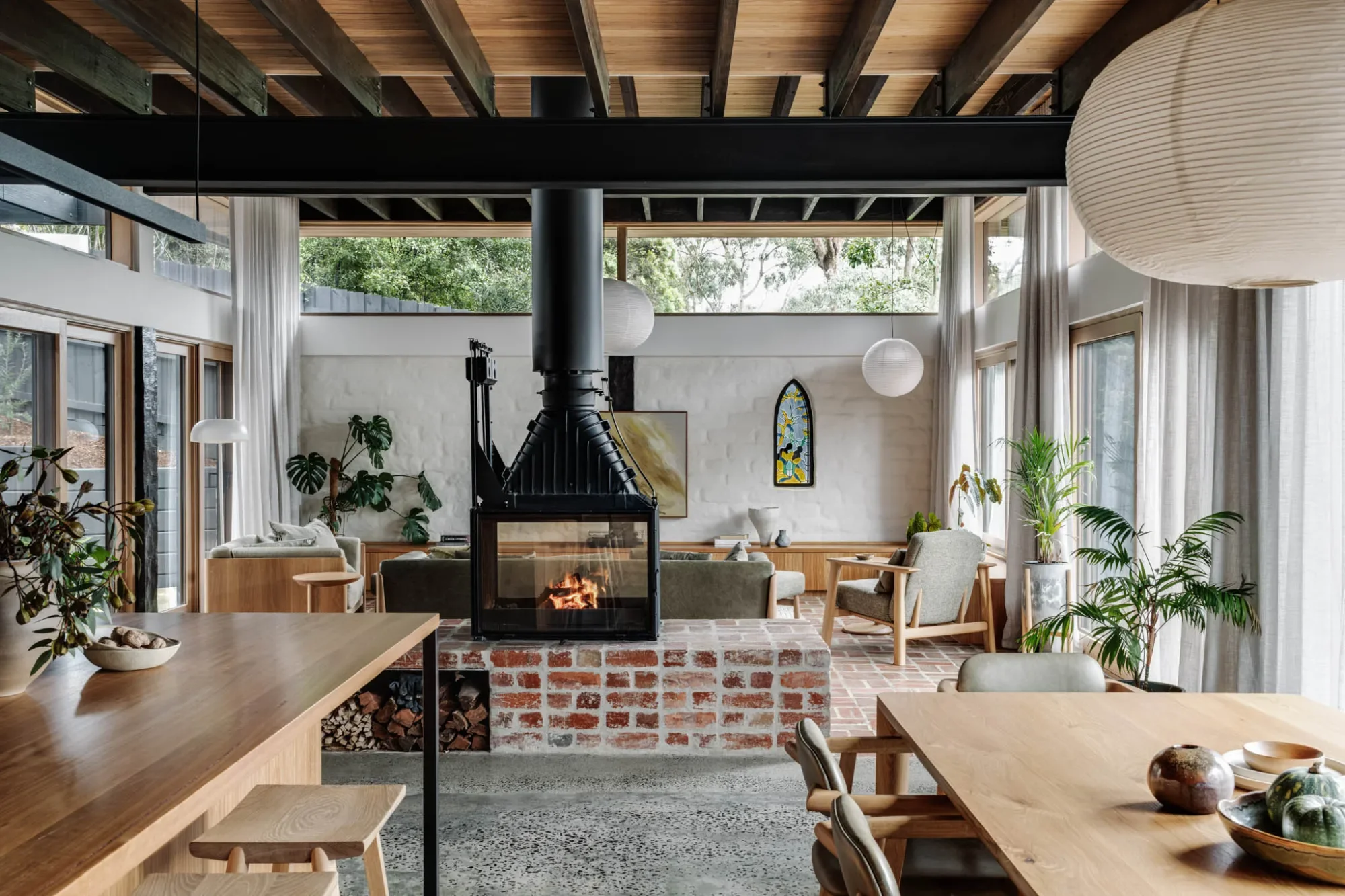 Living room at Mudbrick House, Eltham, with a suspended fireplace on a recycled brick hearth