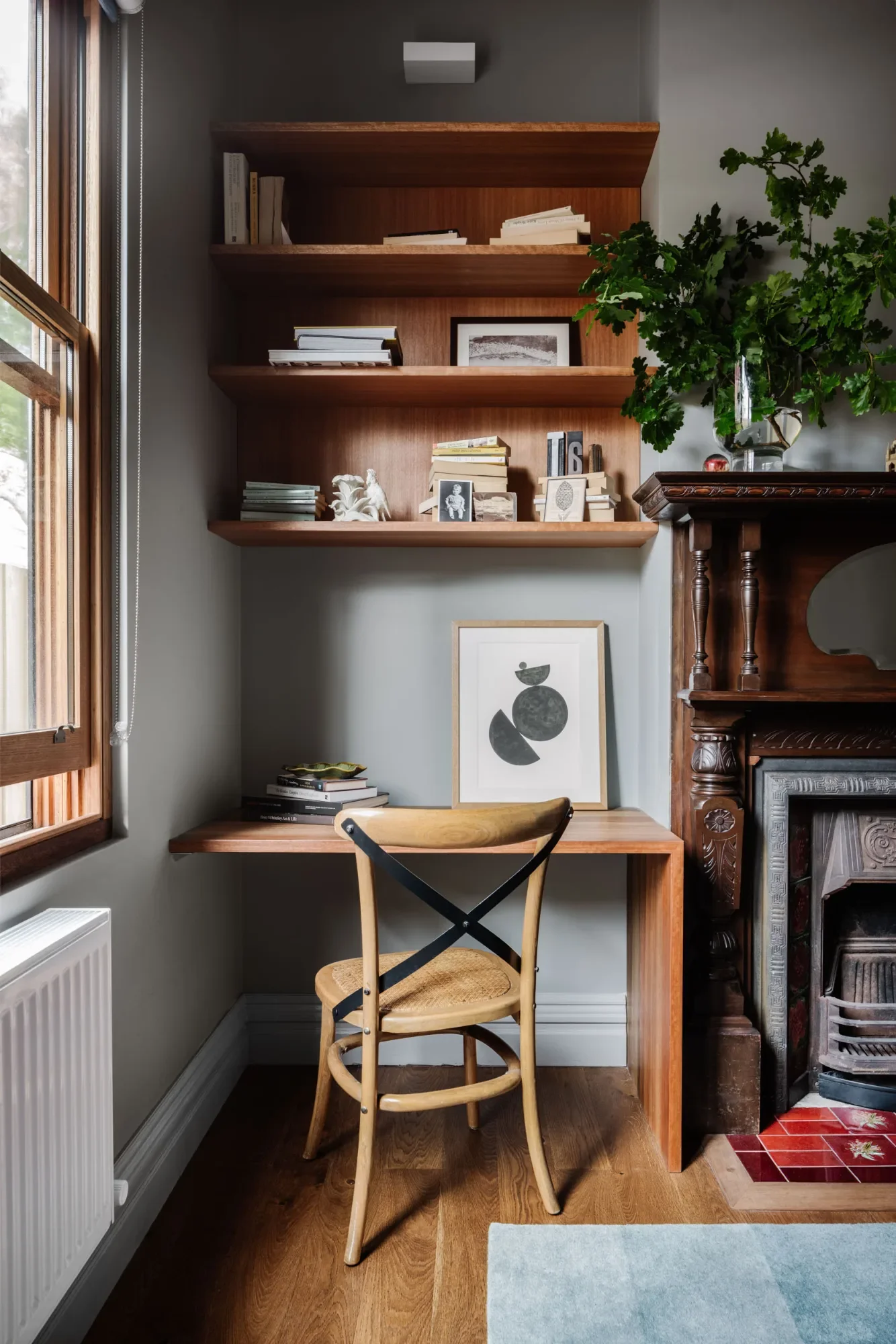 Boys' room at a Pledge Builders project after styling, with tidy shelves, a timber chair and a framed print.