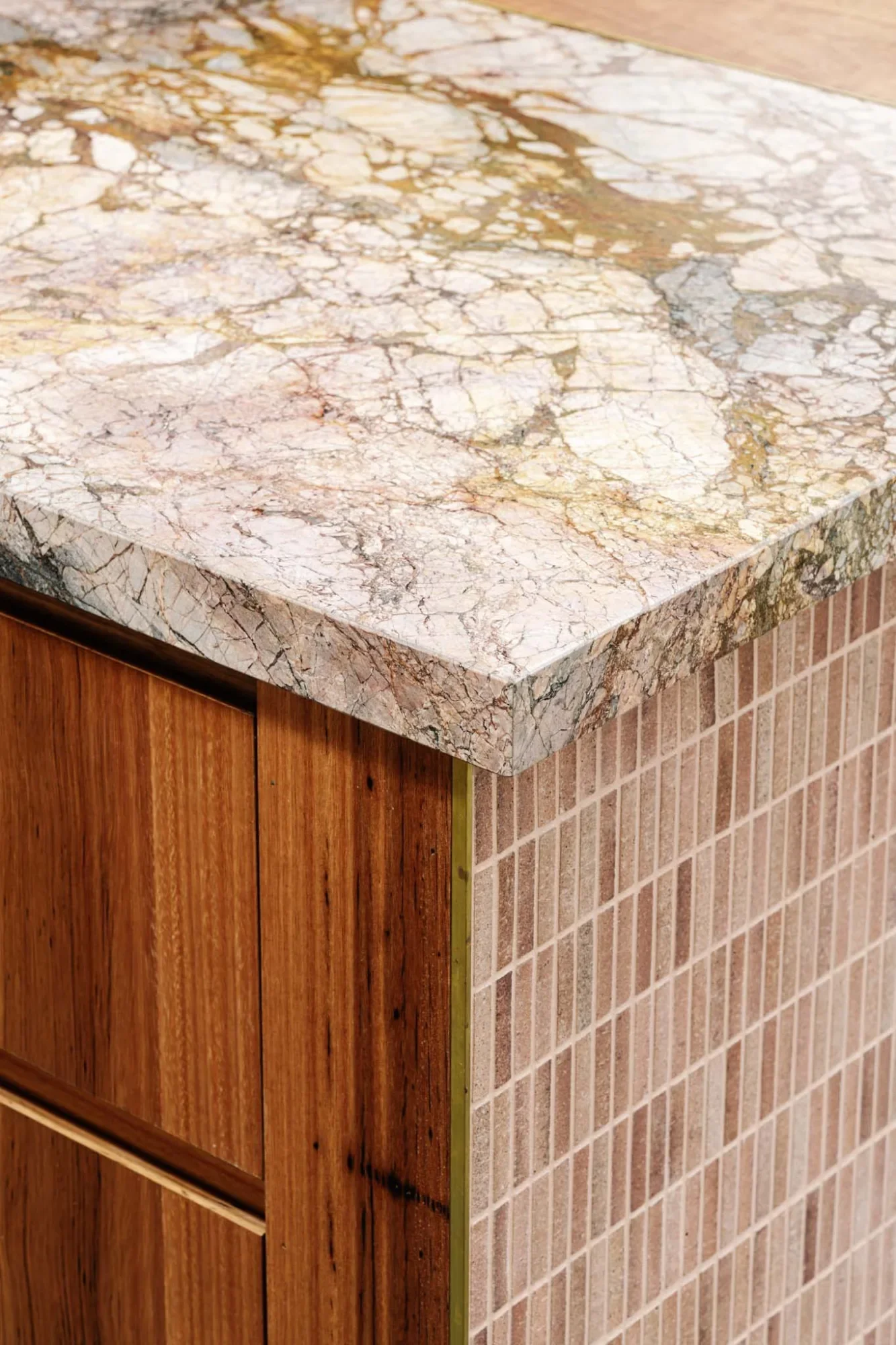 Marble benchtop edge meeting timber joinery and finger tiles at Carlton House