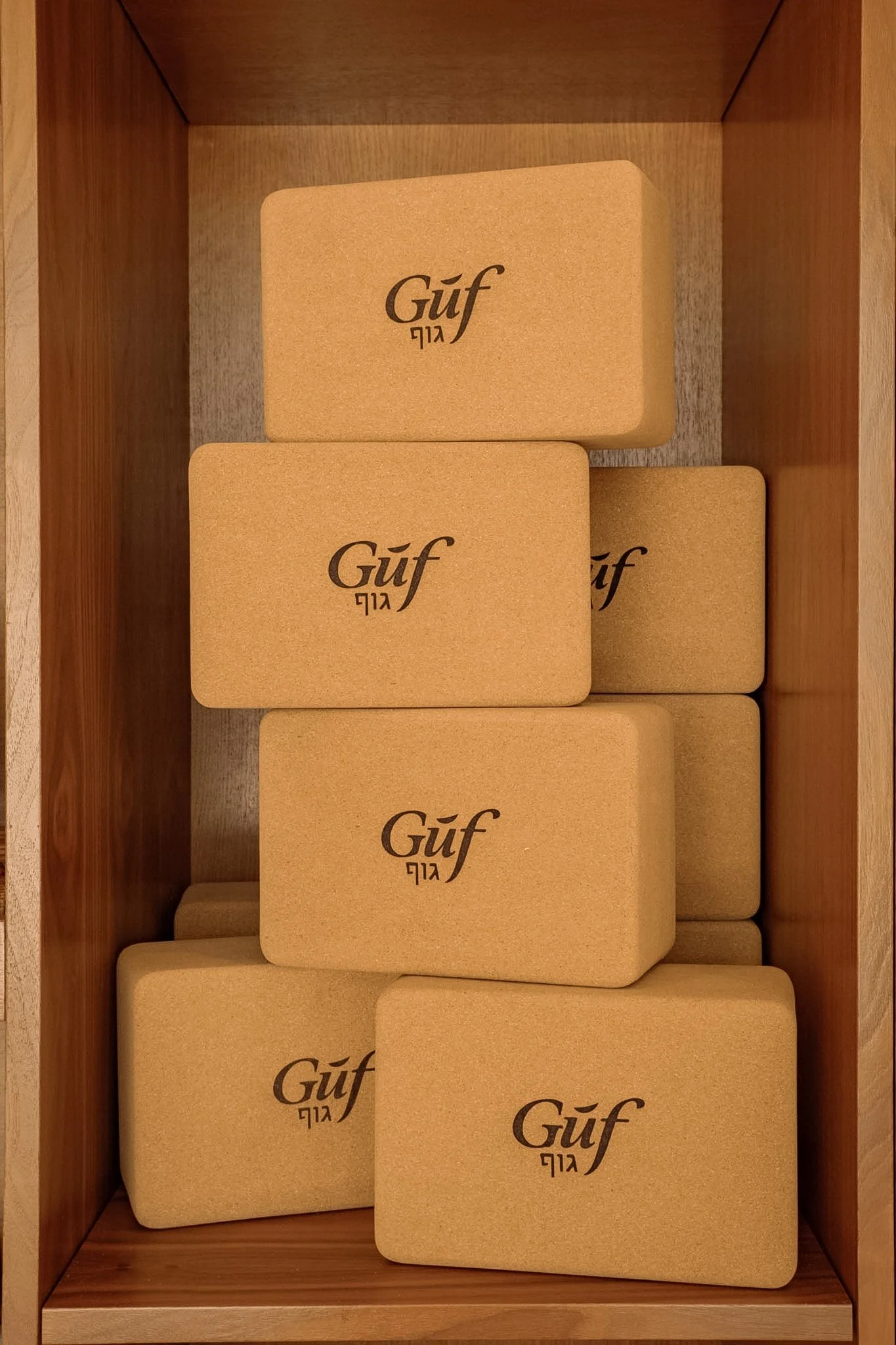 Wooden box with multiple beige bricks labeled with the word "Güf" and some Hebrew text.
