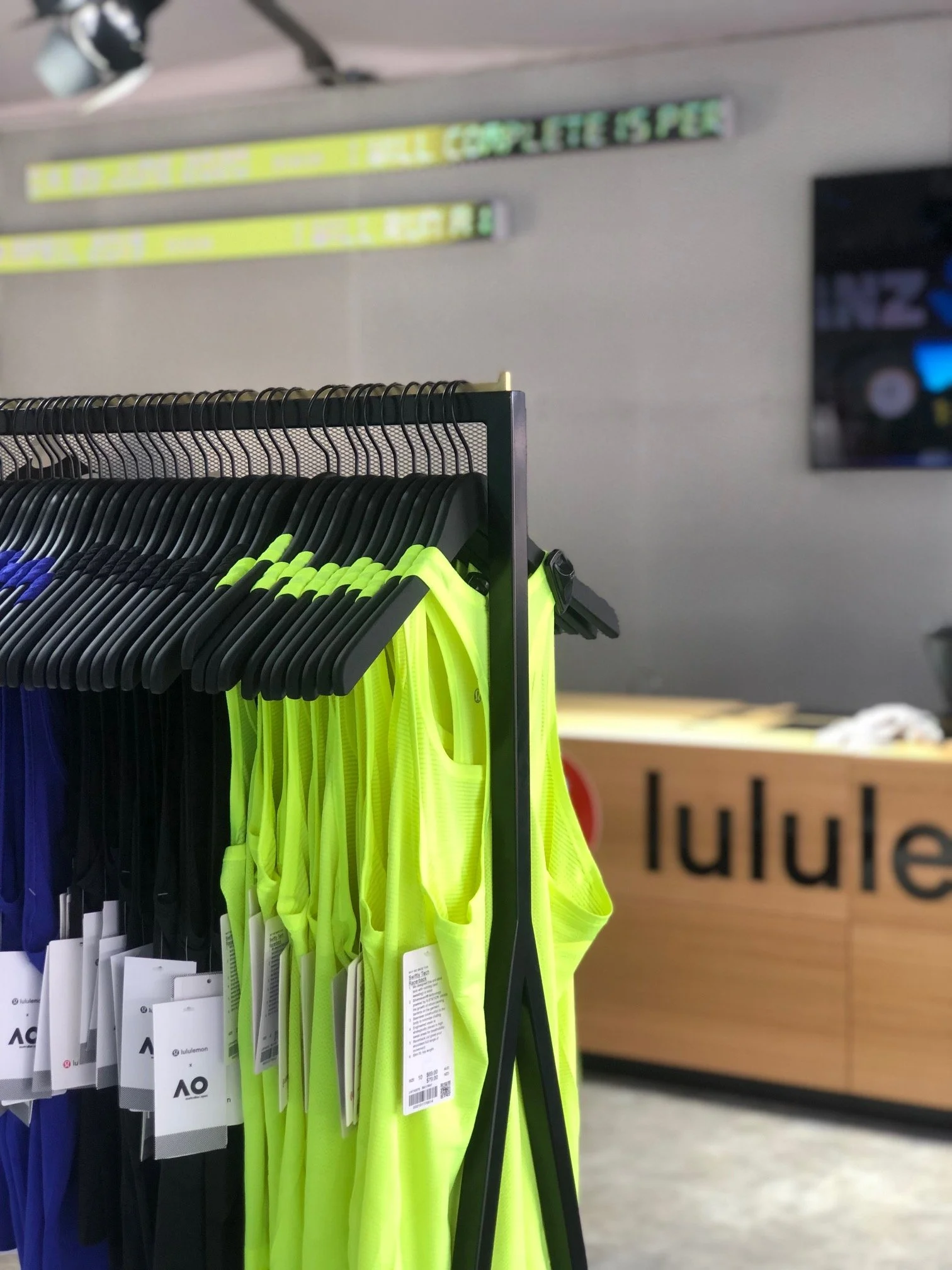 Bright yellow activewear hanging on a clothing rack in an Australian Open retail pop-up store.