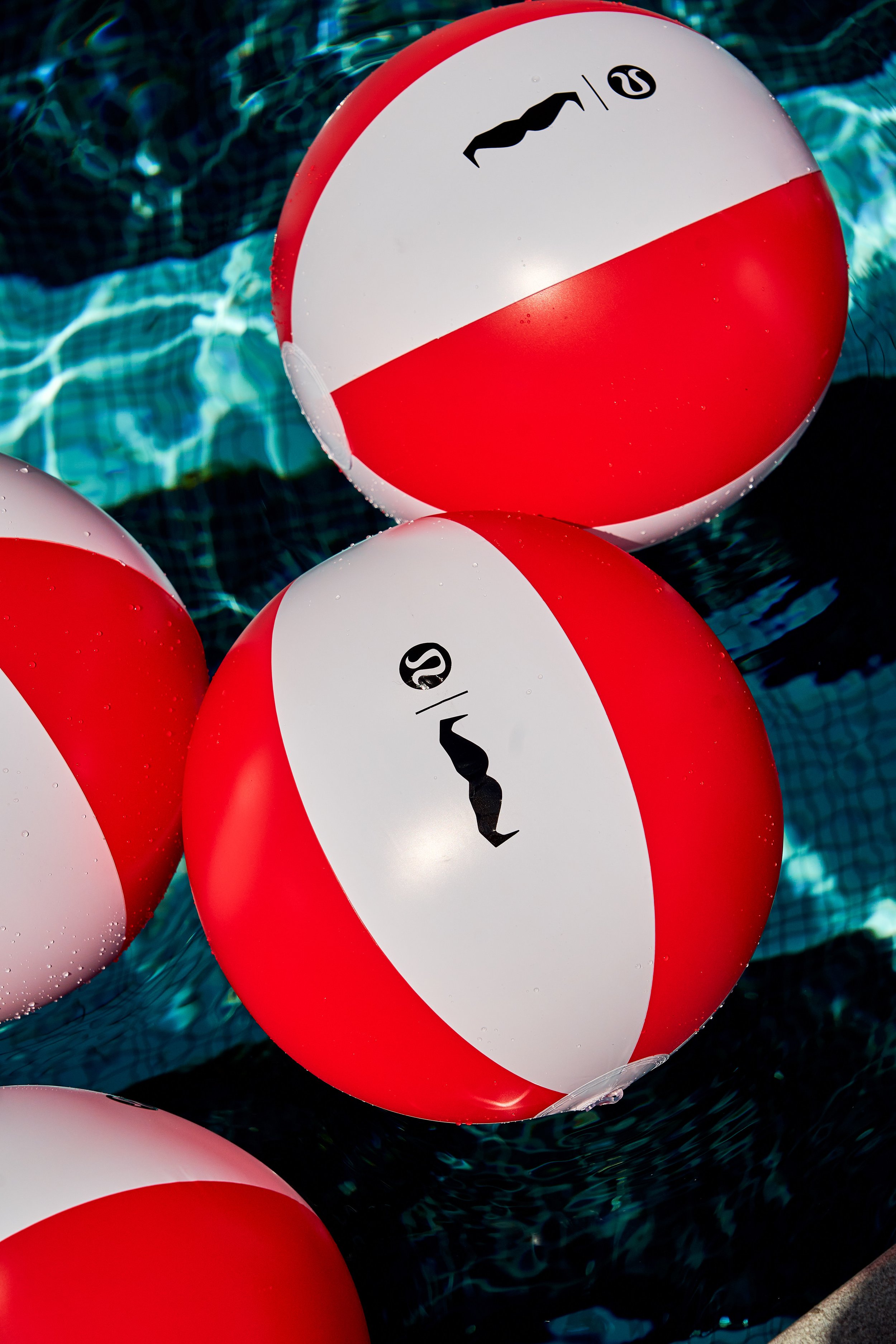 Close-up of red and white beach balls floating on a swimming pool.