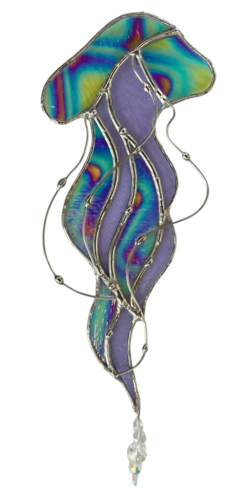 Stained glass art piece shaped like a mermaid with purple and rainbow-colored glass, silver outlines, and a dangling crystal drop at the bottom.