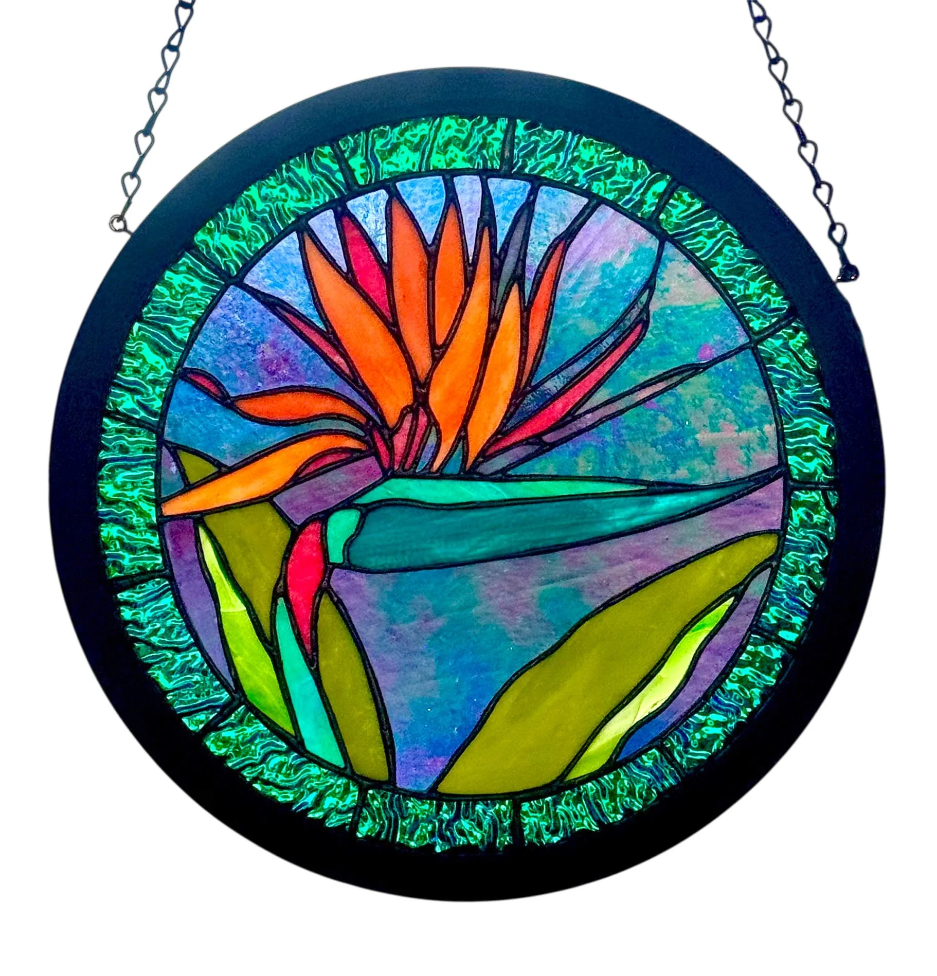 Colorful stained glass hanging with a framed Bird of Paradise design, featuring vibrant shades of green, purple, blue, orange, red, and yellow 