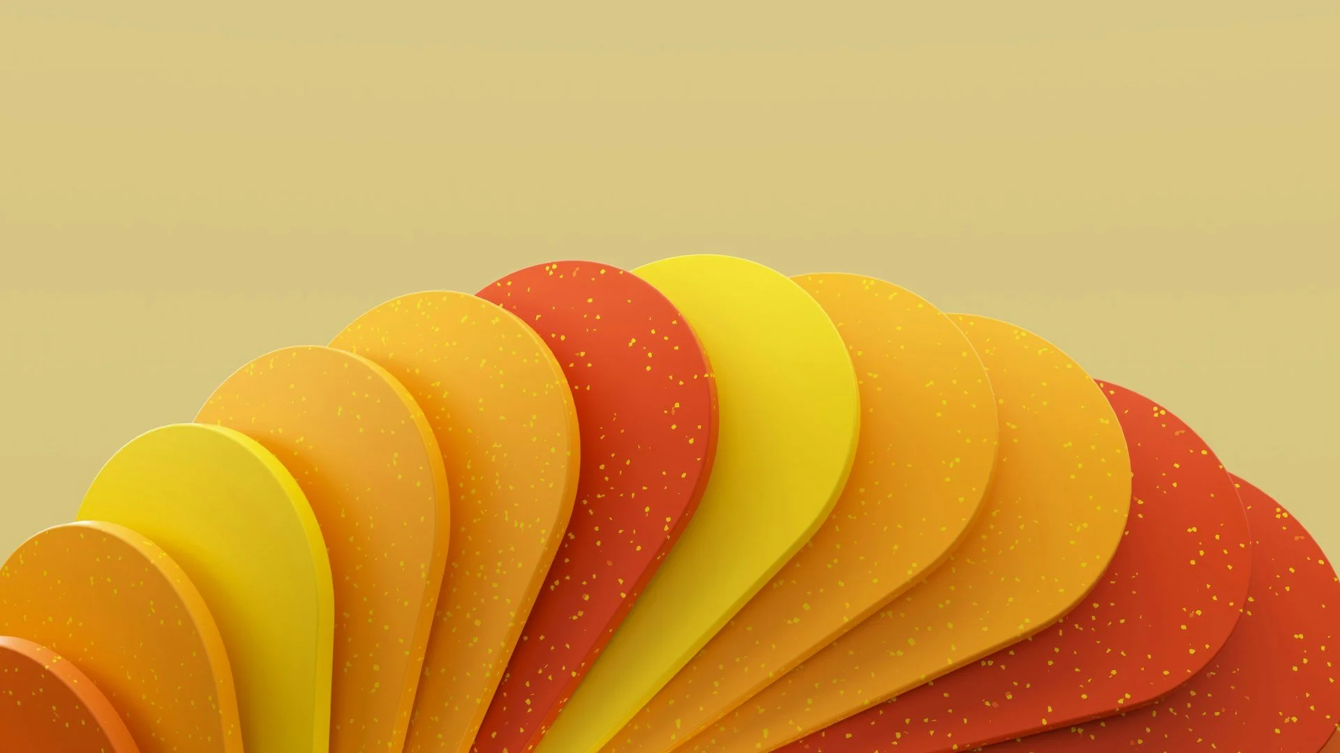 A close-up of colorful, layered, semicircular objects with yellow, orange, and red hues and speckled gold details, arranged in a fan shape against a beige background.