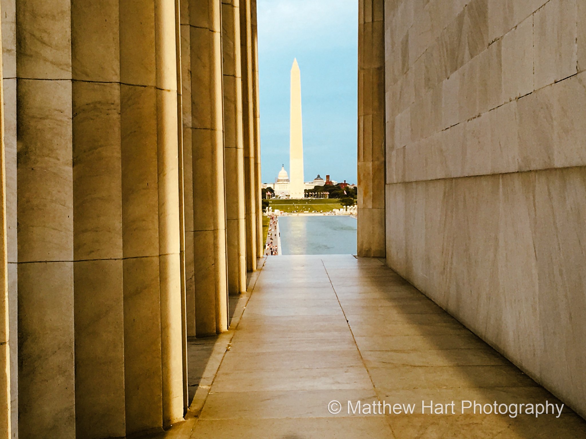 Fine art photograph of the Washington Monument and Reflecting Pool framed between the marble columns and wall of the Lincoln Memorial.