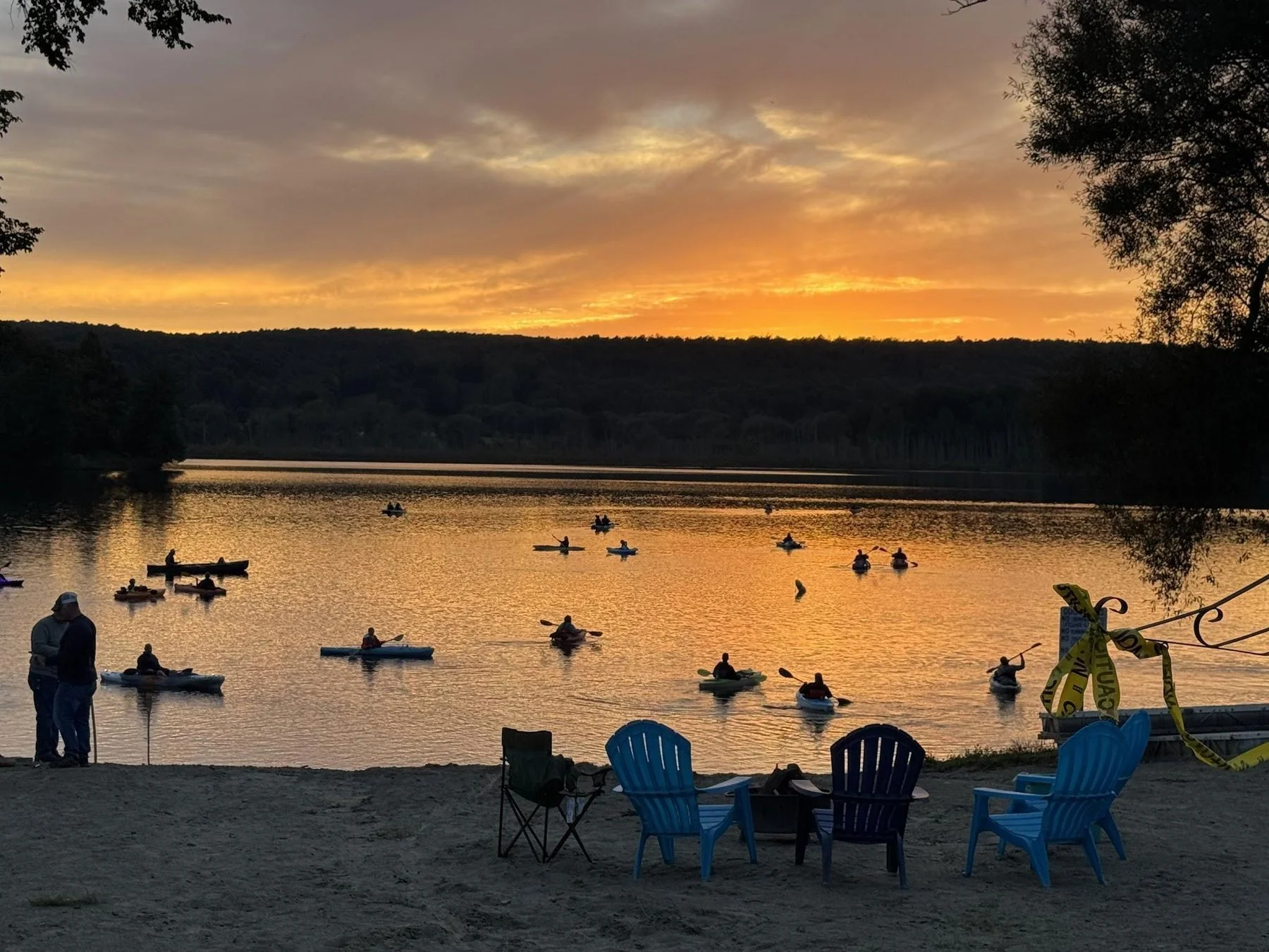 Sunset over Cassadaga Lake with kayaks from the beach