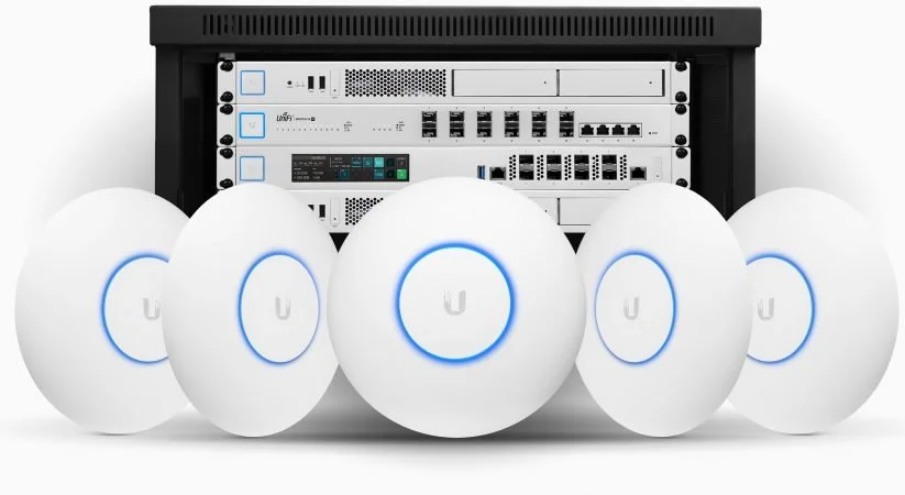 Wireless access points arranged in front of a server rack with networking equipment.