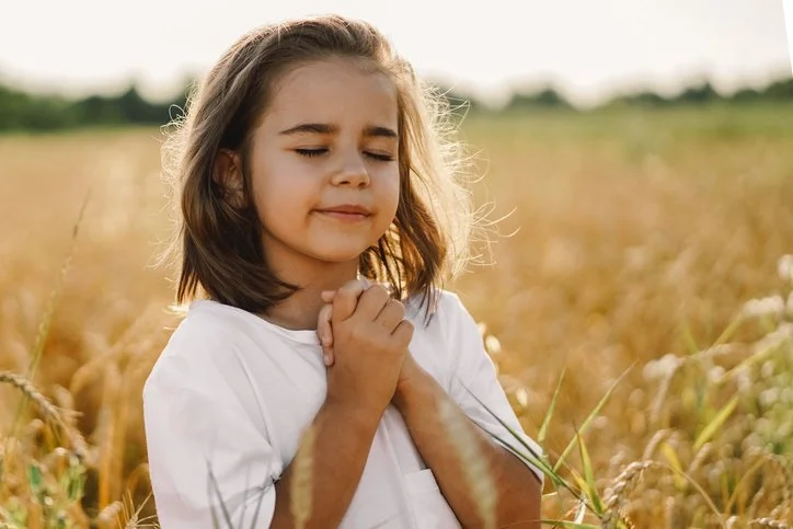 Girl with eyes closed in prayer, representing Faith-Based Services in the For-Purpose Sector