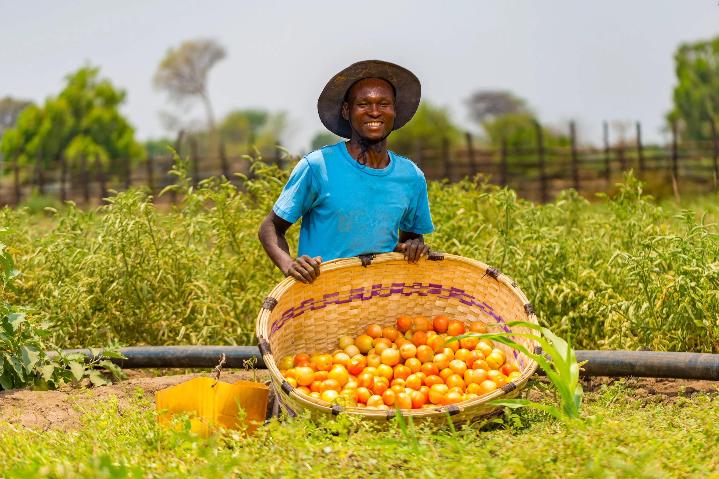 Man in third world country with basket of fruit.