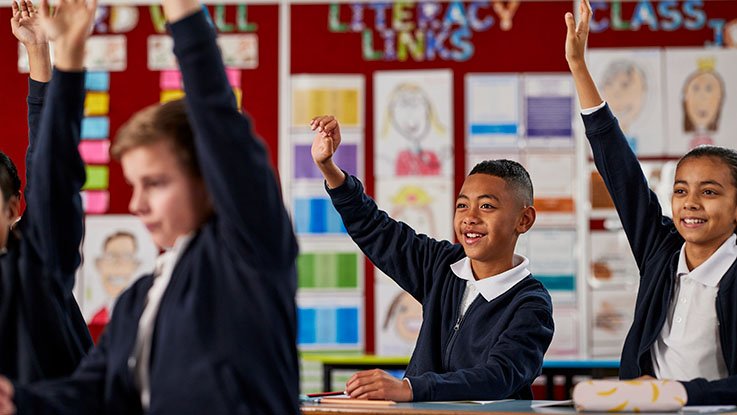 Kids with hands up in classroom