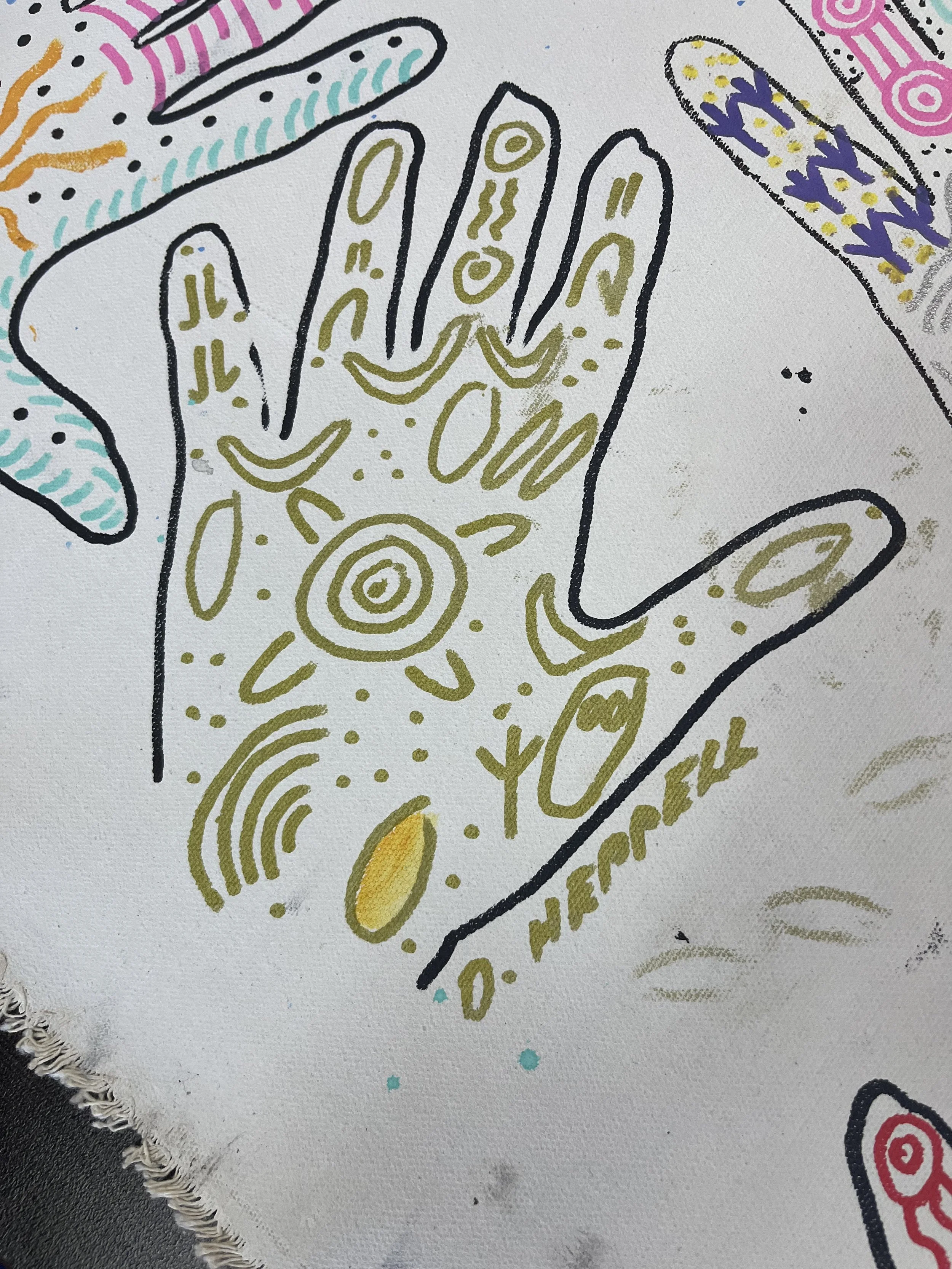 A white fabric with a colorful abstract design including black outlines, yellow, purple, pink, orange, and teal patterns, and small splashes of teal paint.