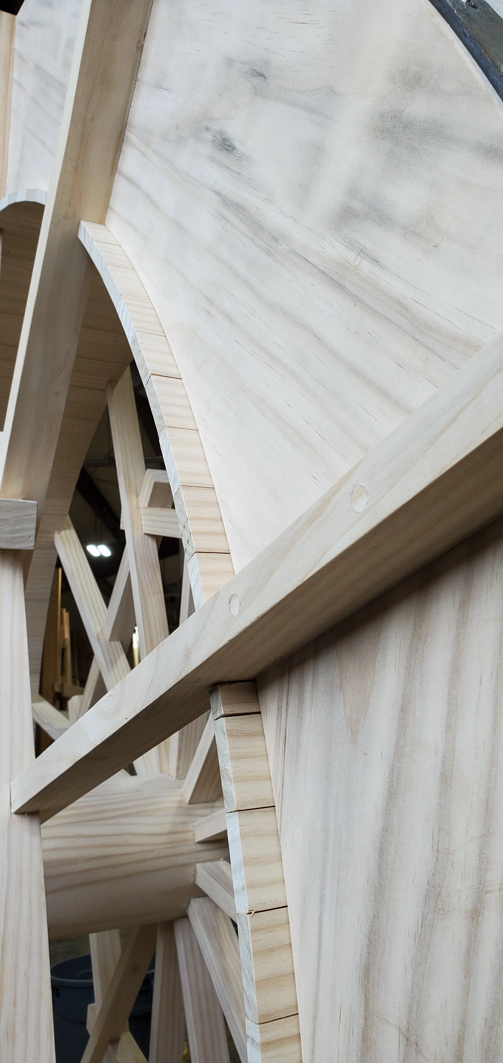 Close-up of unfinished wooden furniture or cabinetry frame with visible screws and joinery.