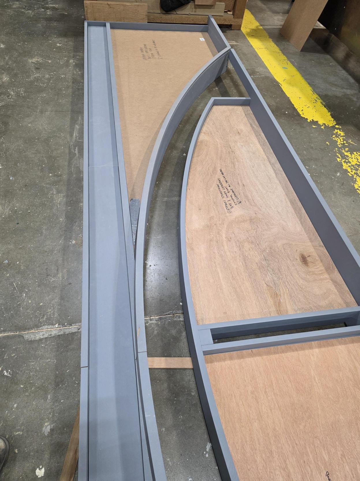 Two semi-circular wooden and metal display tables in a workshop.