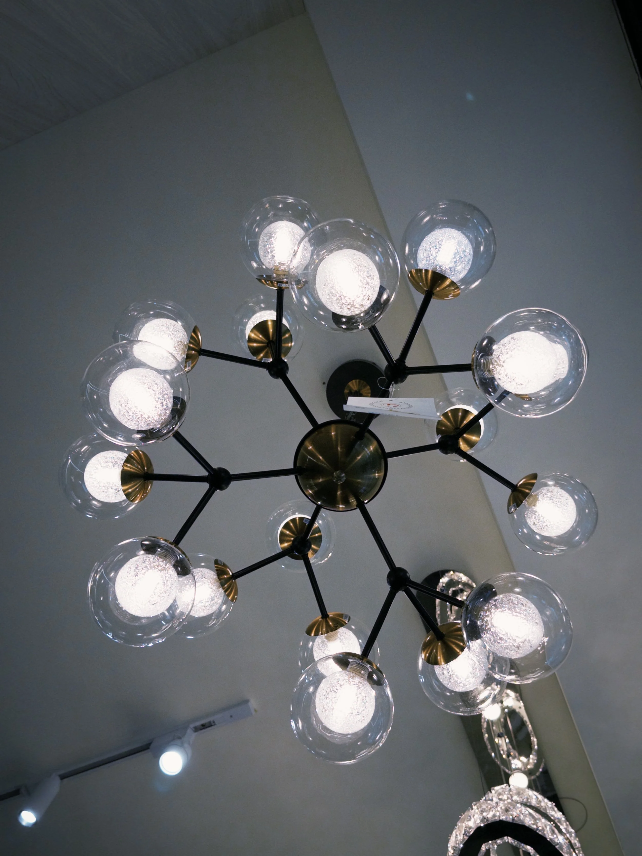 A modern chandelier with multiple glass globe lights and metallic accents hanging from the ceiling.