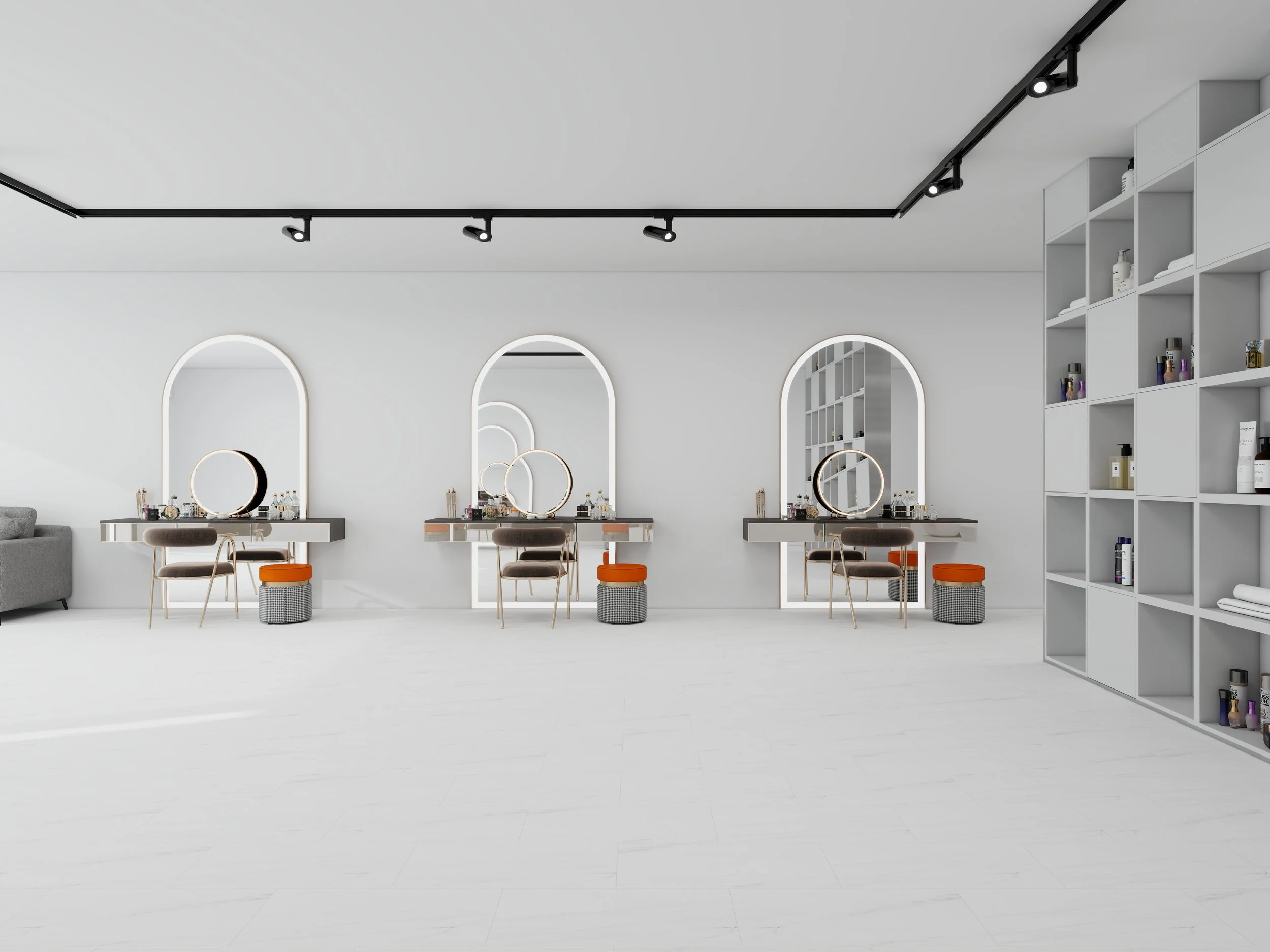 Interior of a modern beauty salon with white walls, large mirrors with glowing lights, styling chairs, and a tall shelving unit filled with hair and beauty products.
