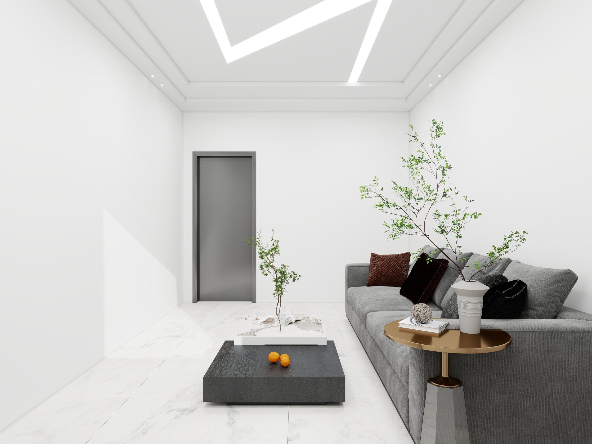 Modern minimalist living room with white walls and ceiling, a gray sofa with black and brown pillows, a gold side table, a potted plant, a black and gray marble coffee table with oranges on it, and a gray door.