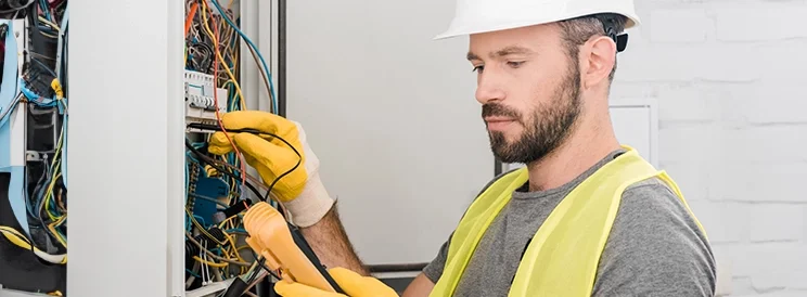 Fix-It Construction Services electrician testing electrical panel with multimeter Harrisonburg VA