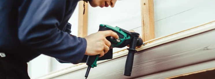 Fix-It Construction Services siding installation on exterior home using power drill Harrisonburg VA