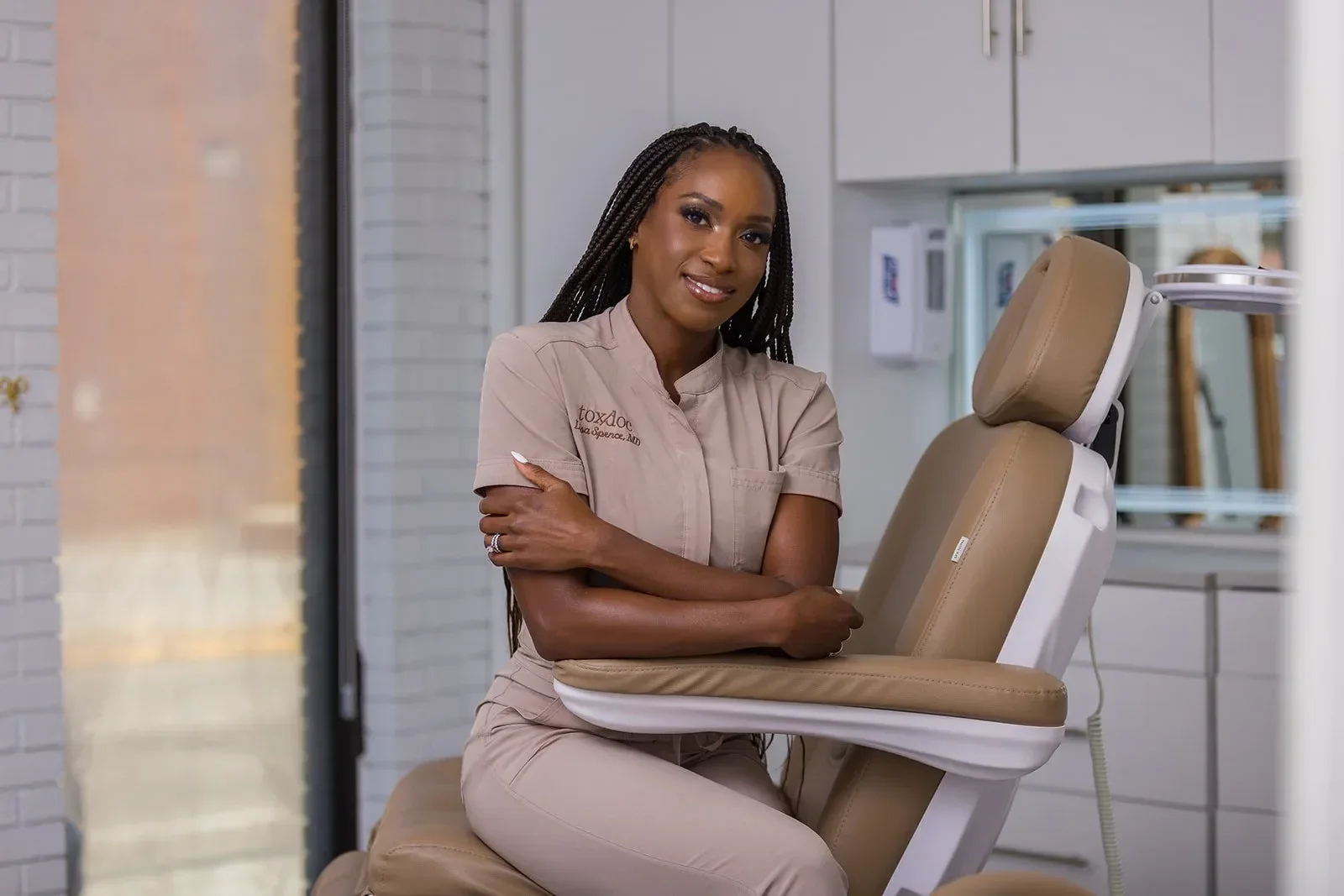 Dr. Spence sitting in a dental or medical chair in a clinical setting.