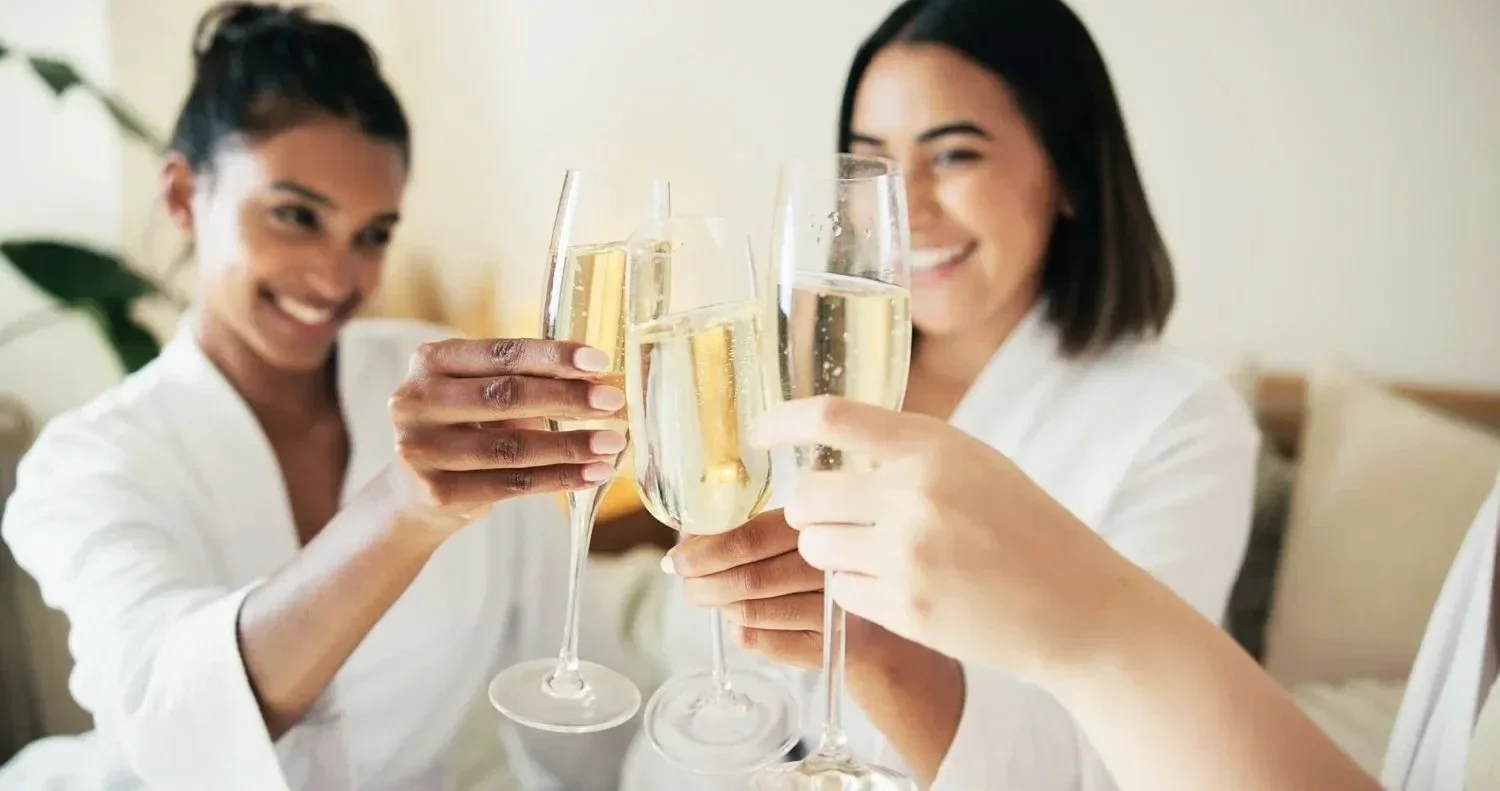 Three women raising glasses of champagne in a toast.