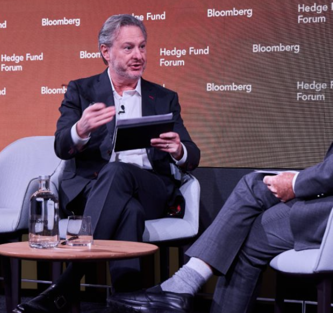 Colin Lancaster speaking at the Bloomberg Hedge Fund Forum during a seated discussion on hedge funds, macro markets, and investment strategy.