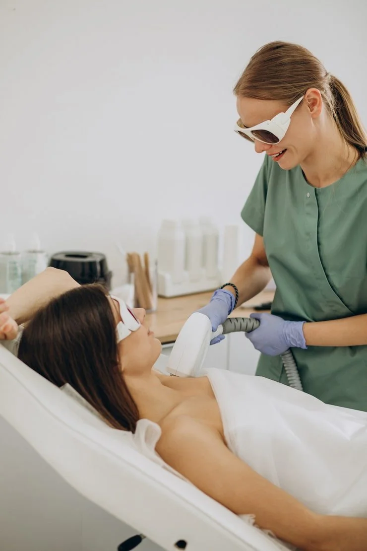 Medical professional using laser device on patient in a clinic setting