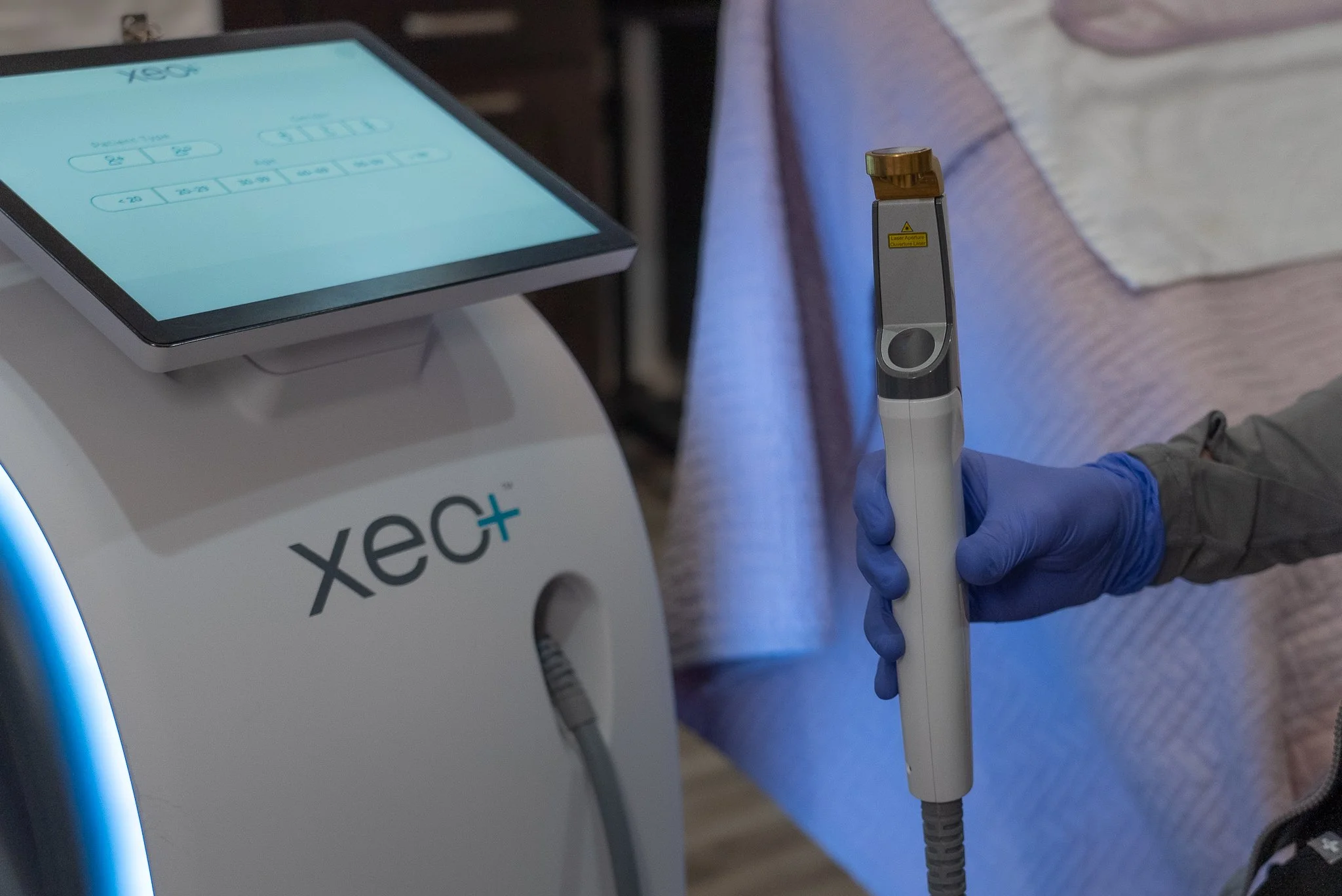 Person wearing gloves holding a medical device connected to a machine labeled 'vex+.'