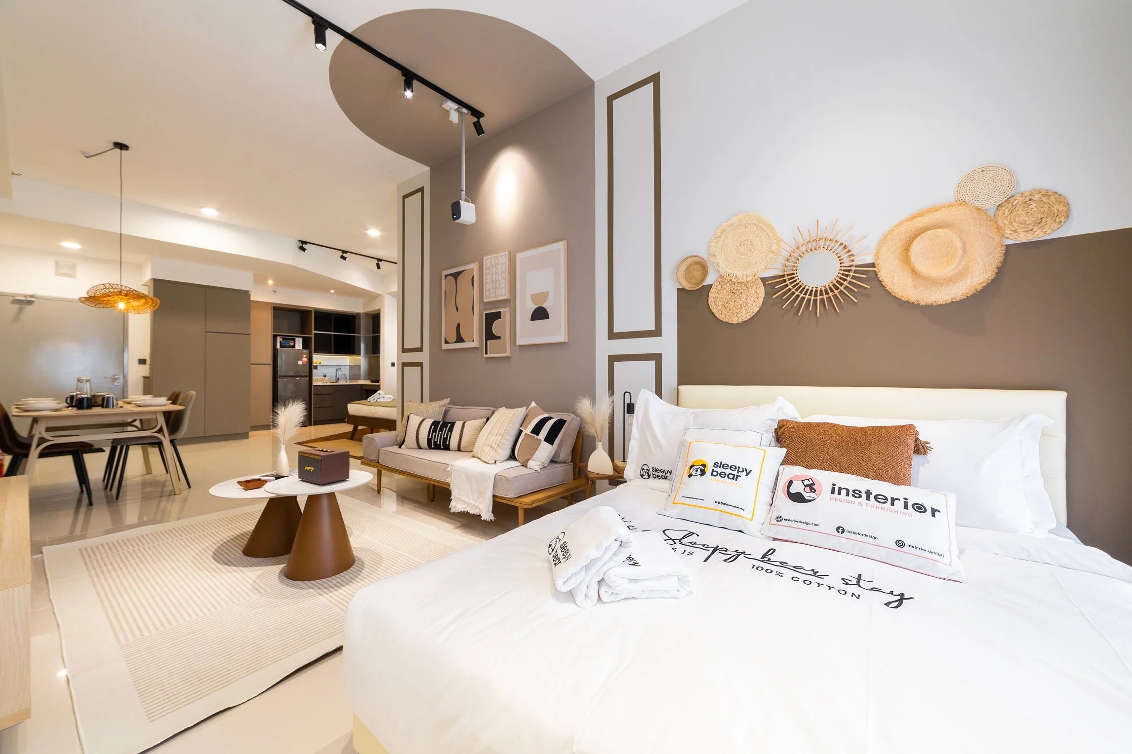 Interior of Sleepy Bear Stays properties. Modern living room with a beige sofa, decorative pillows, a coffee table, wall art, and woven wall hangings.