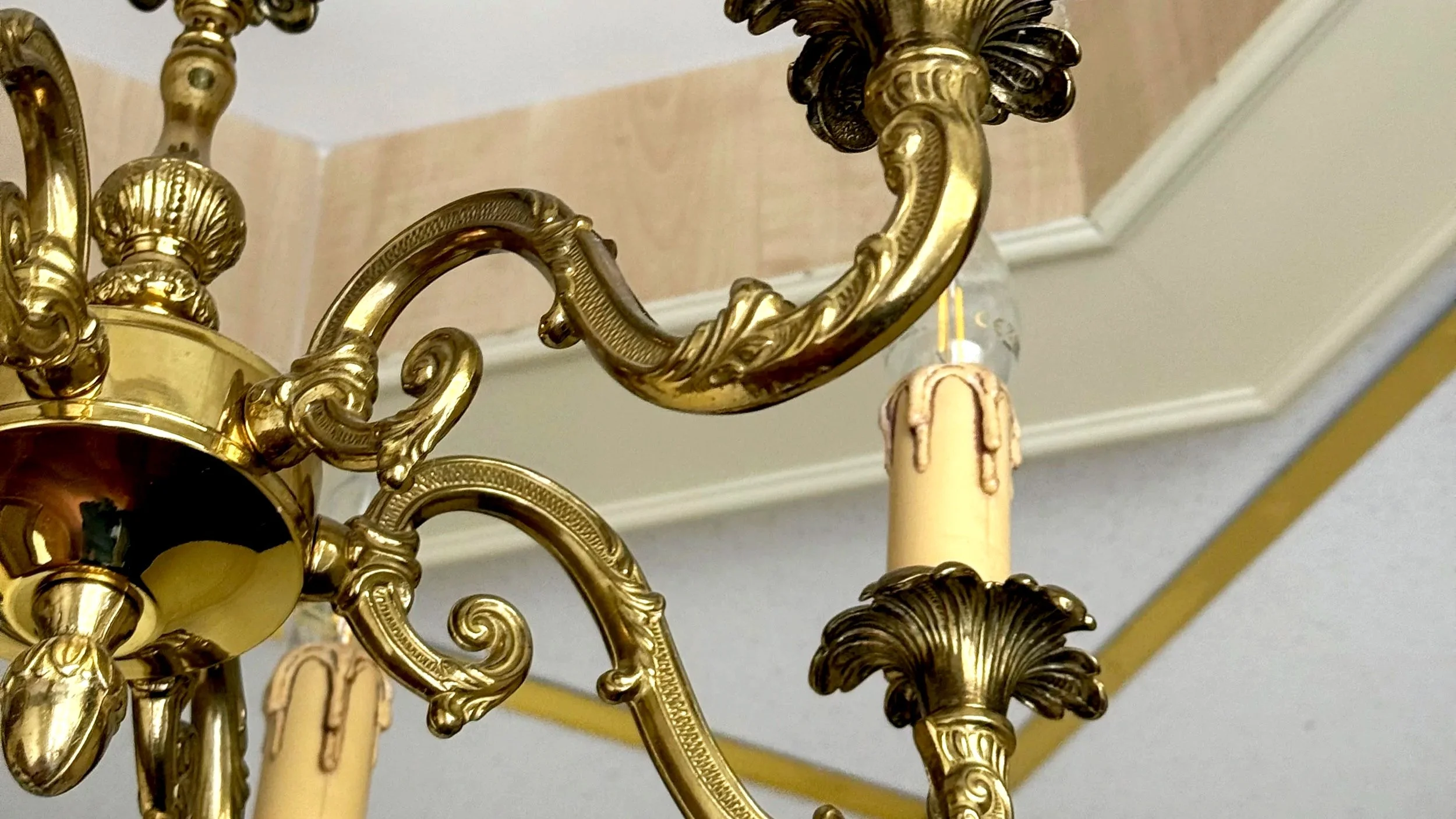 Guld- og messingkrone med udsmykkede detaljer og en lysestage.