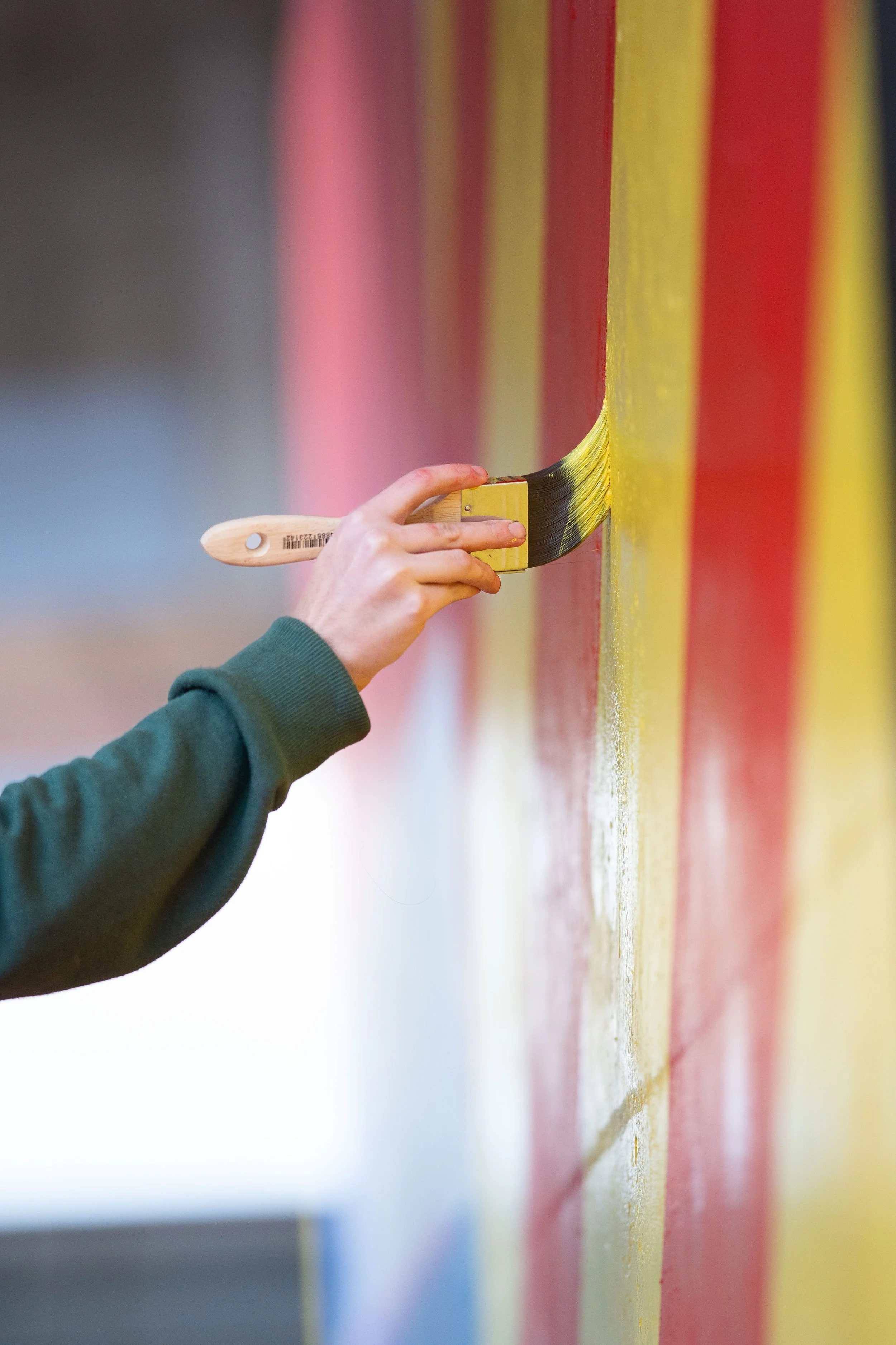 side-view-mural-painting-SouthBank-Brisbane-photography-woman-paints-yellow-and-red-stripes.jpg