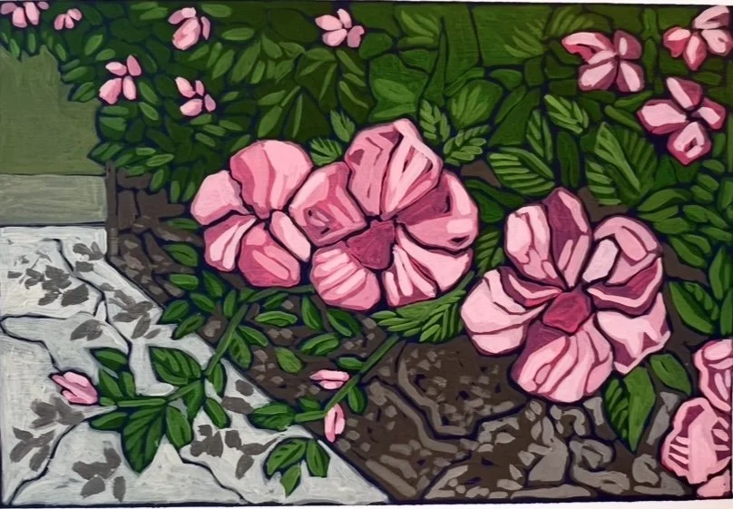 Painted pink flowers with green leaves next to a gray stone pathway.