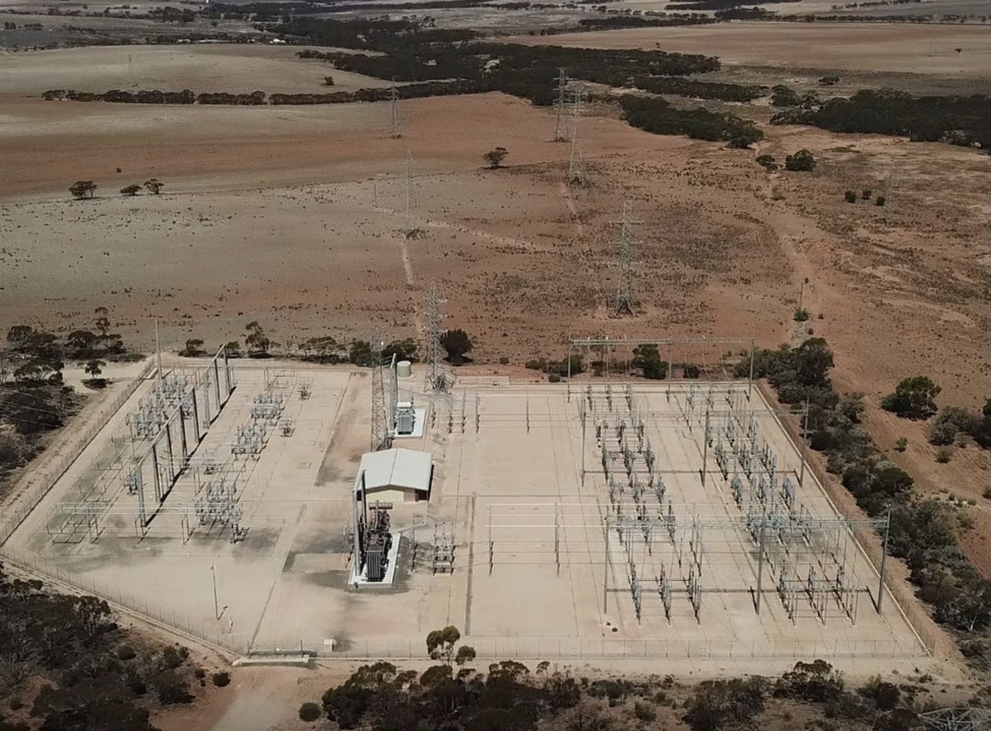 Revera Energy Robertstown Project image of an aerial view of a large electrical substation with power lines in a rural area with fields and scattered trees.