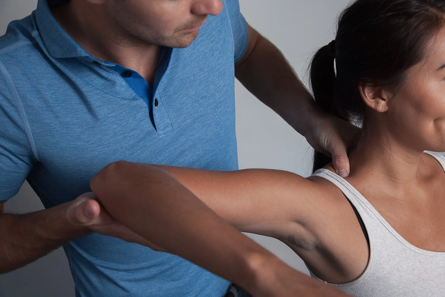 Dr Derek Page performing chiropractic treatment on a woman's shoulder and neck