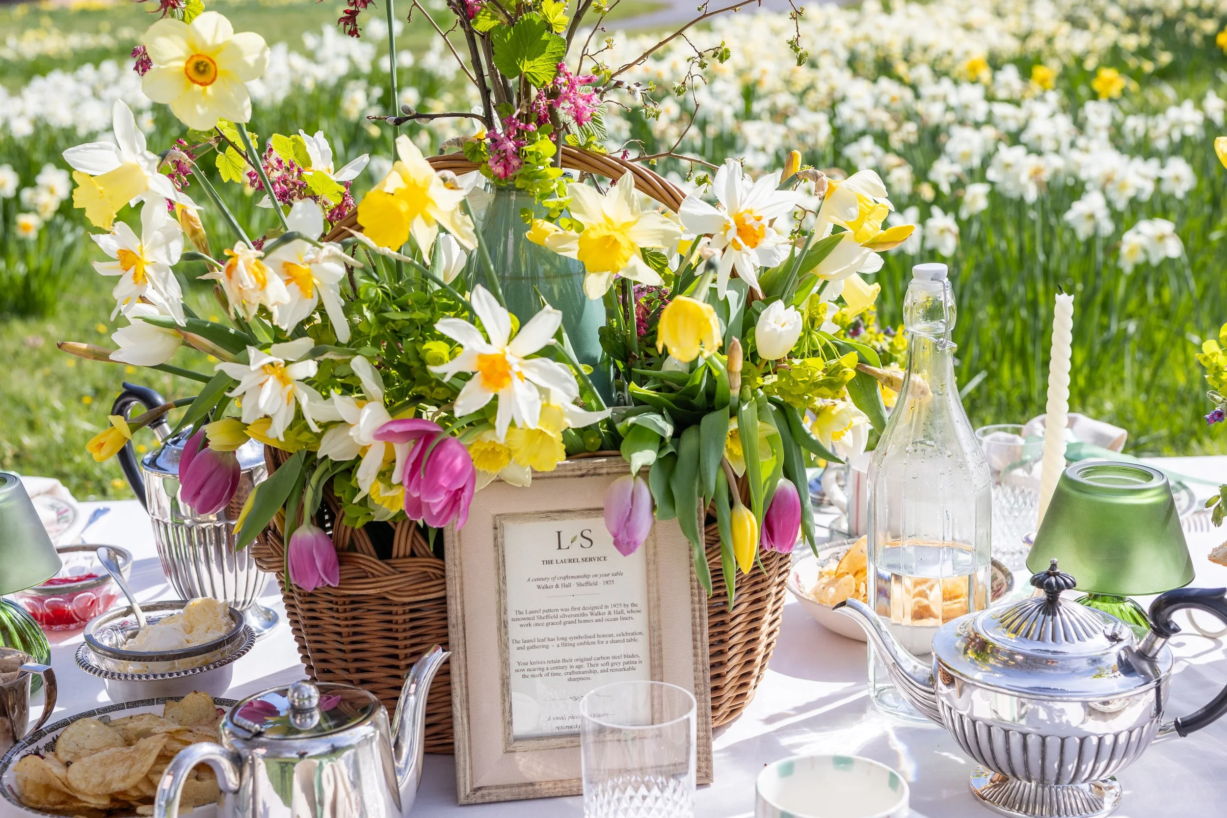 Spring tablescape by Laura Somborn with daffodils and seasonal blooms, arranged for an Easter outdoor gathering.
